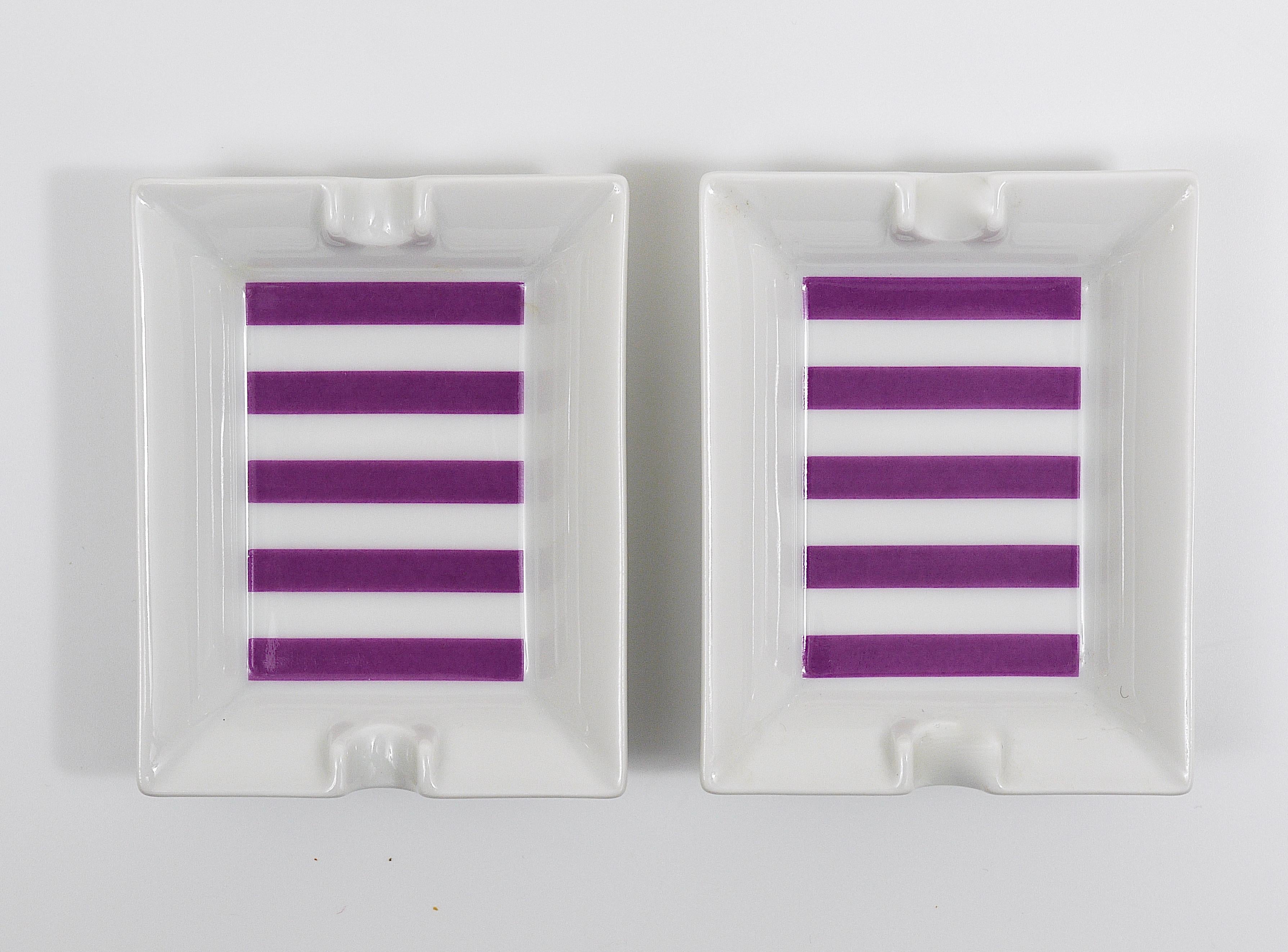 A pair of charming petite triangular modernists ashtray from the 1950s. Made of china with violet stripes and white shiny glaze. Lovely pieces, executed by Augarten Vienna, Austria. In very good condition.