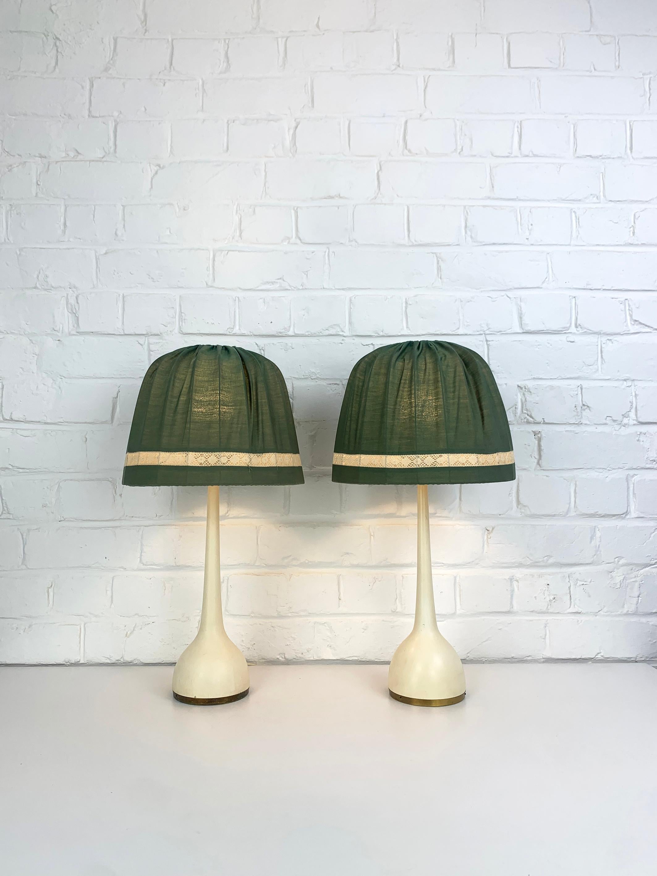 Lampes de table conçues dans les années 1960 par Hans-Agne Agnes avec abat-jour d'origine.

Base en bois massif peinte en blanc cassé (finition d'origine) avec accent en laiton. Abats-jour originaux en tissu vert. 

Fabriqué par AB Markaryd en