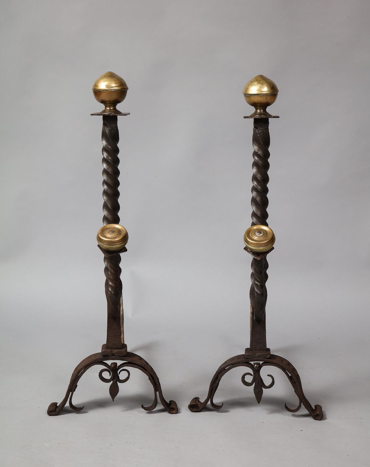 Fine pair of 17th century bronze and wrought iron andirons, having ringed suppressed ball finials on square collars above spiral twist shafts with forward facing spit supports with similar finials and spiral twists, standing on arched legs with