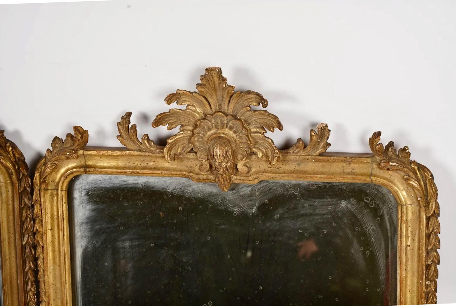 This is a very unusual pair of late 17th or early 18th century Italian Baroque Girandoles. The girandoles feature a finely executed carved gilt wood frame that is surmounted by a finely carved and gilt acanthus leaf crest. The acanthus leaf candle