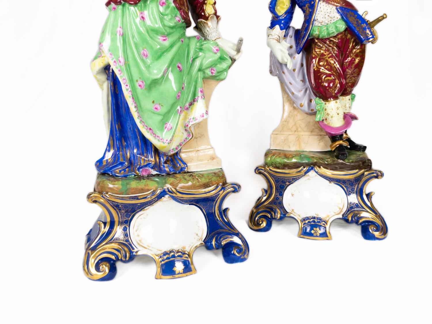 Coppia di statuette in porcellana dipinte a mano in stile barocco, raffiguranti una dama elegante e un moschettiere galante, graziosamente in posa con abiti del XVIII secolo ricchi di dettagli. 
Realizzate in Germania nel XX secolo, queste statue