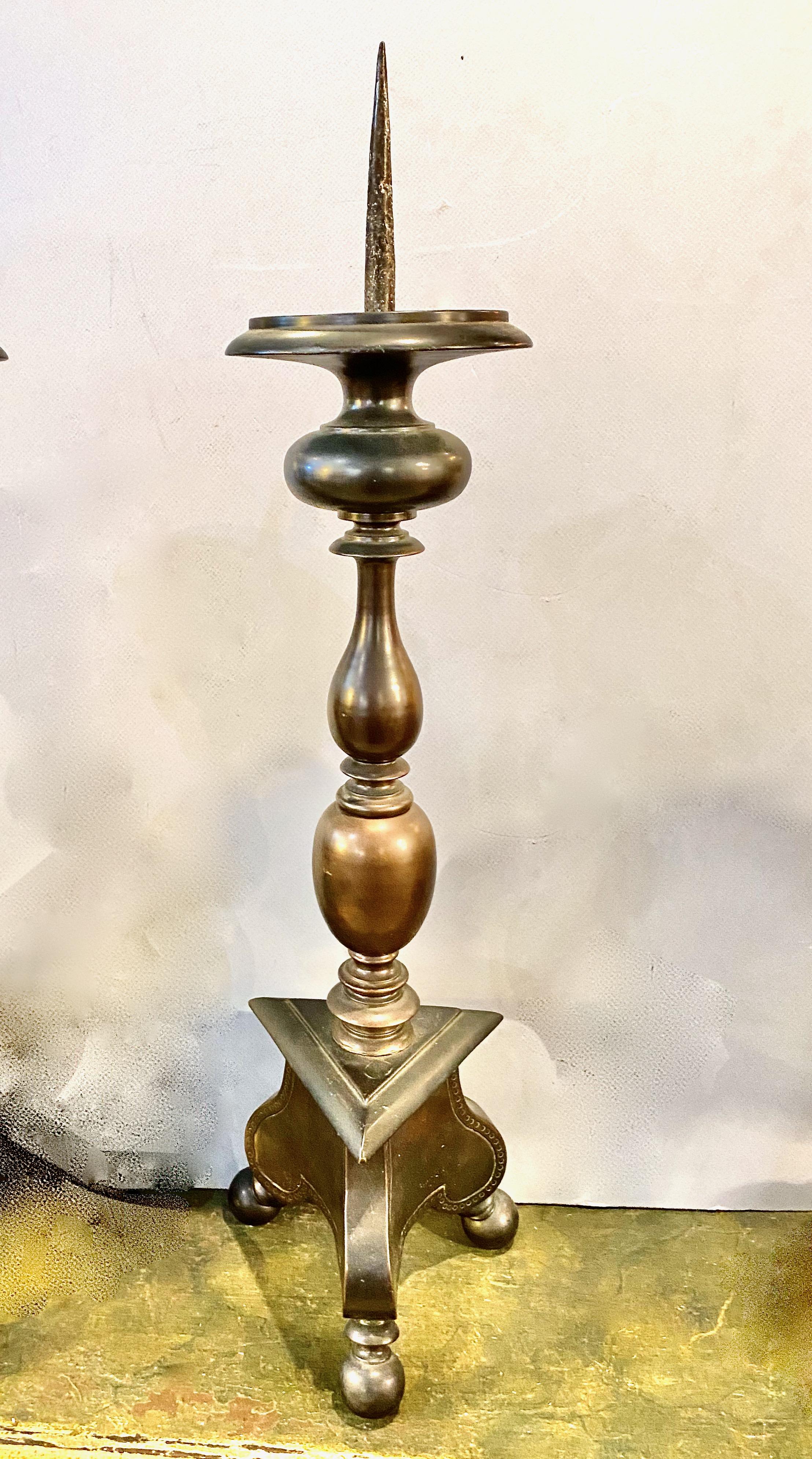 This is a good example of early 18th century Italian solid bronze pricket candlesticks. The tripartite base is supported by ball feet and is detailed with a hammered design. These large sticks measure 22 inches in height, excluding the pricket. One
