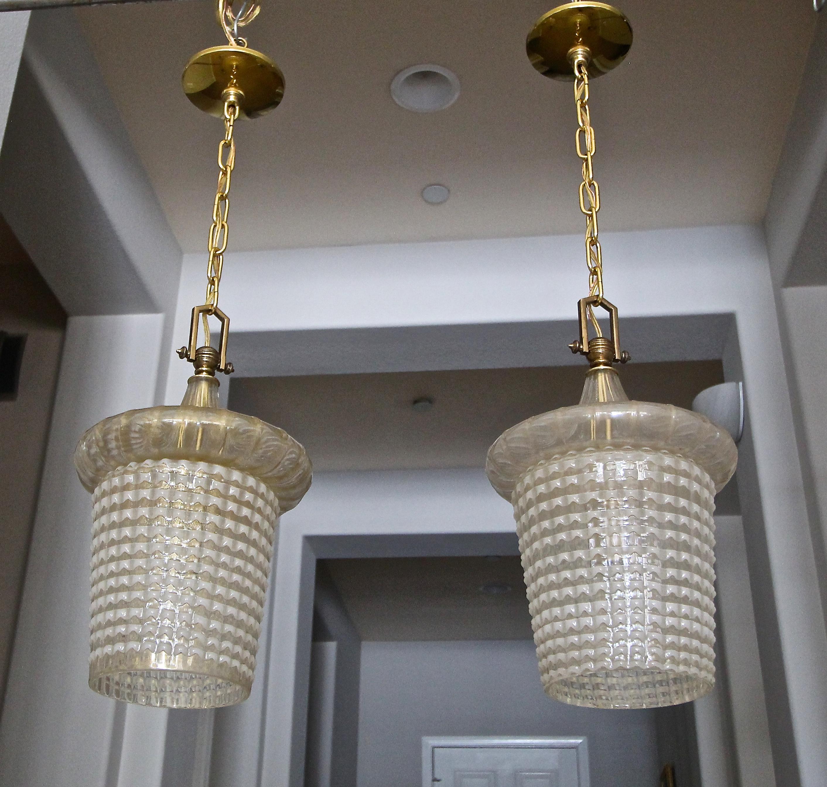 Pair of lantern shaped Murano ceiling light pendants by Ercole Barovier Toso. The top portion is ribbed with gold inclusions, the bottom half is in the 