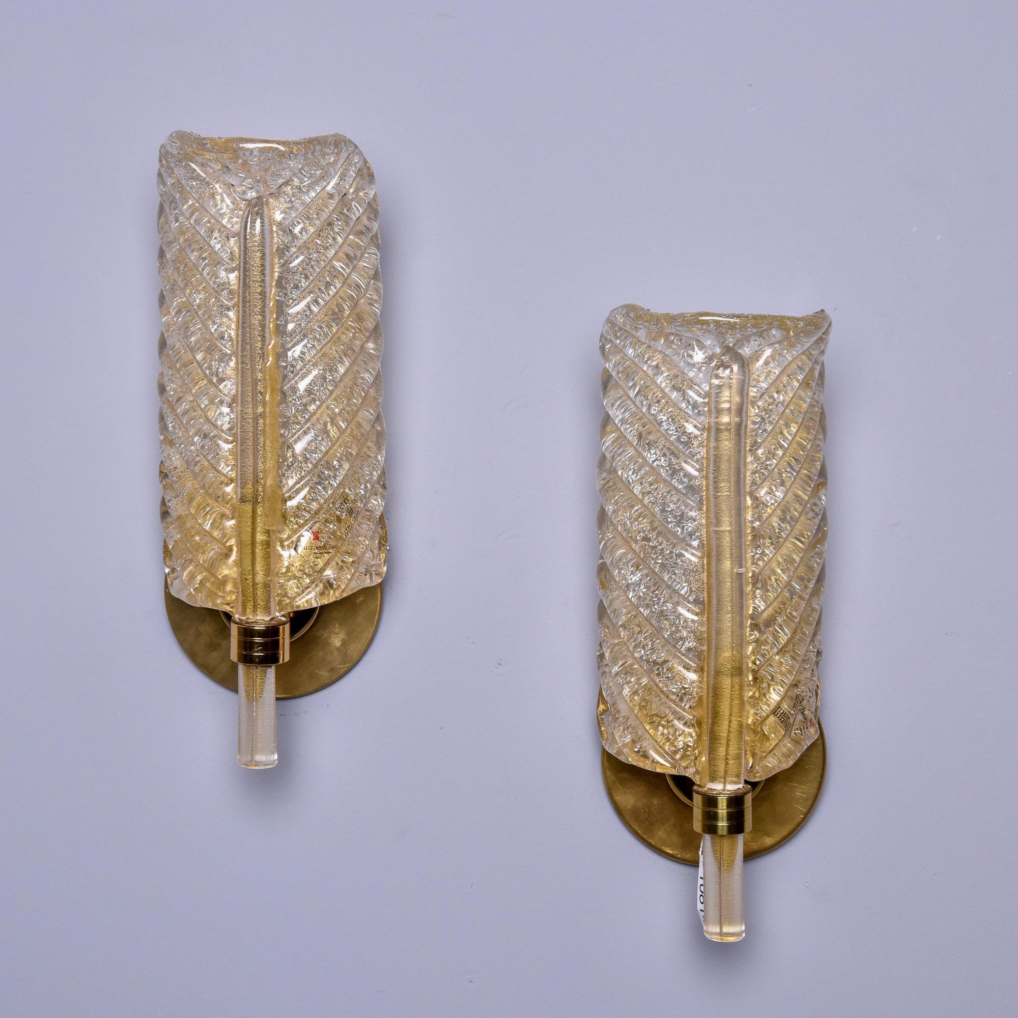 Found in Italy, this pair of circa 1980s Barovier & Toso leaf or feather form sconces date from the 1980s. Clear Murano glass with gold inclusions, polished brass back plates and hardware. Each sconce has a single, standard sized socket that has