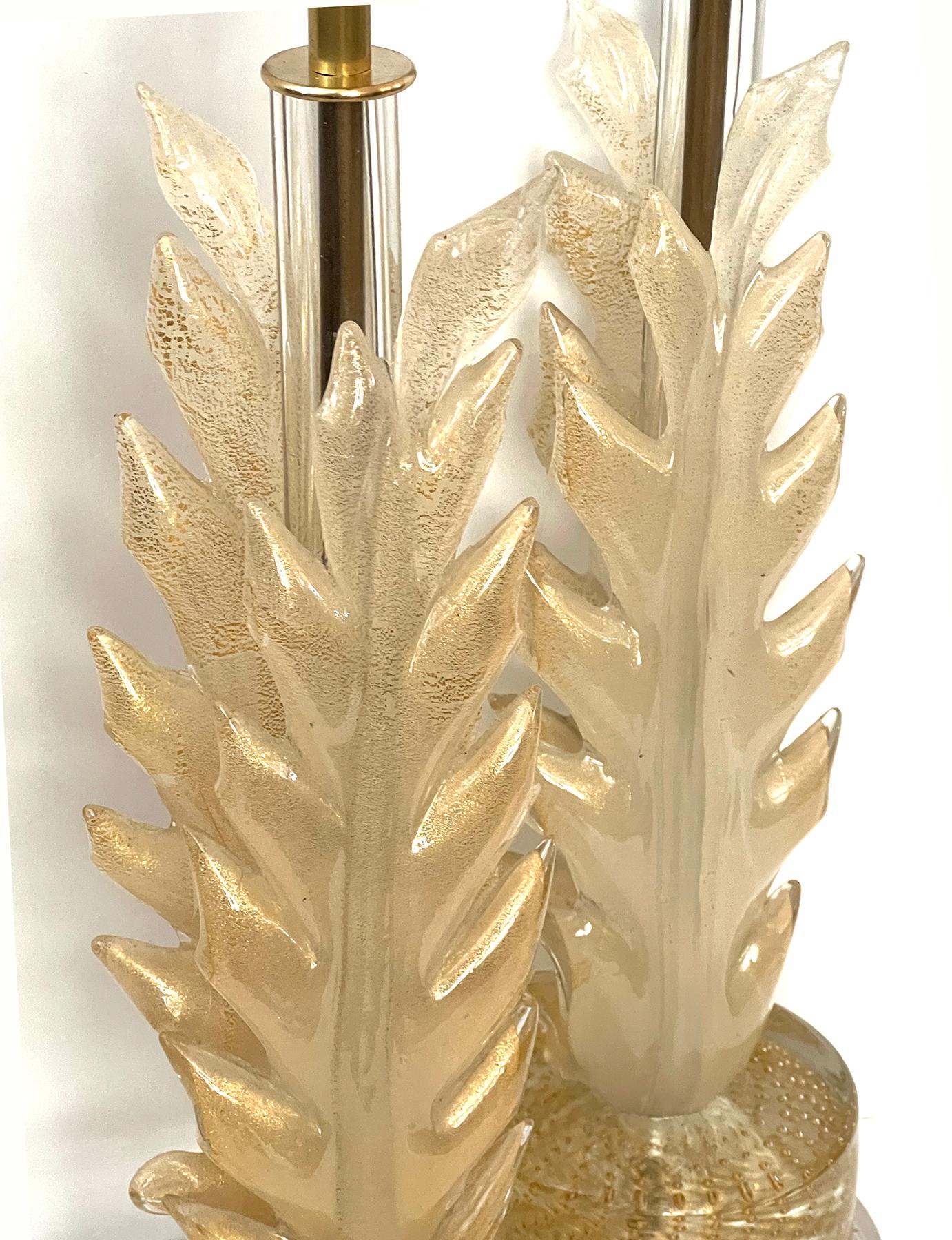 each with central glass support surrounded by two tall opposing leaves of translucent gold aventurine glass all raised on a thick gold bullicante disk over a later Lucite base; height: 16.5