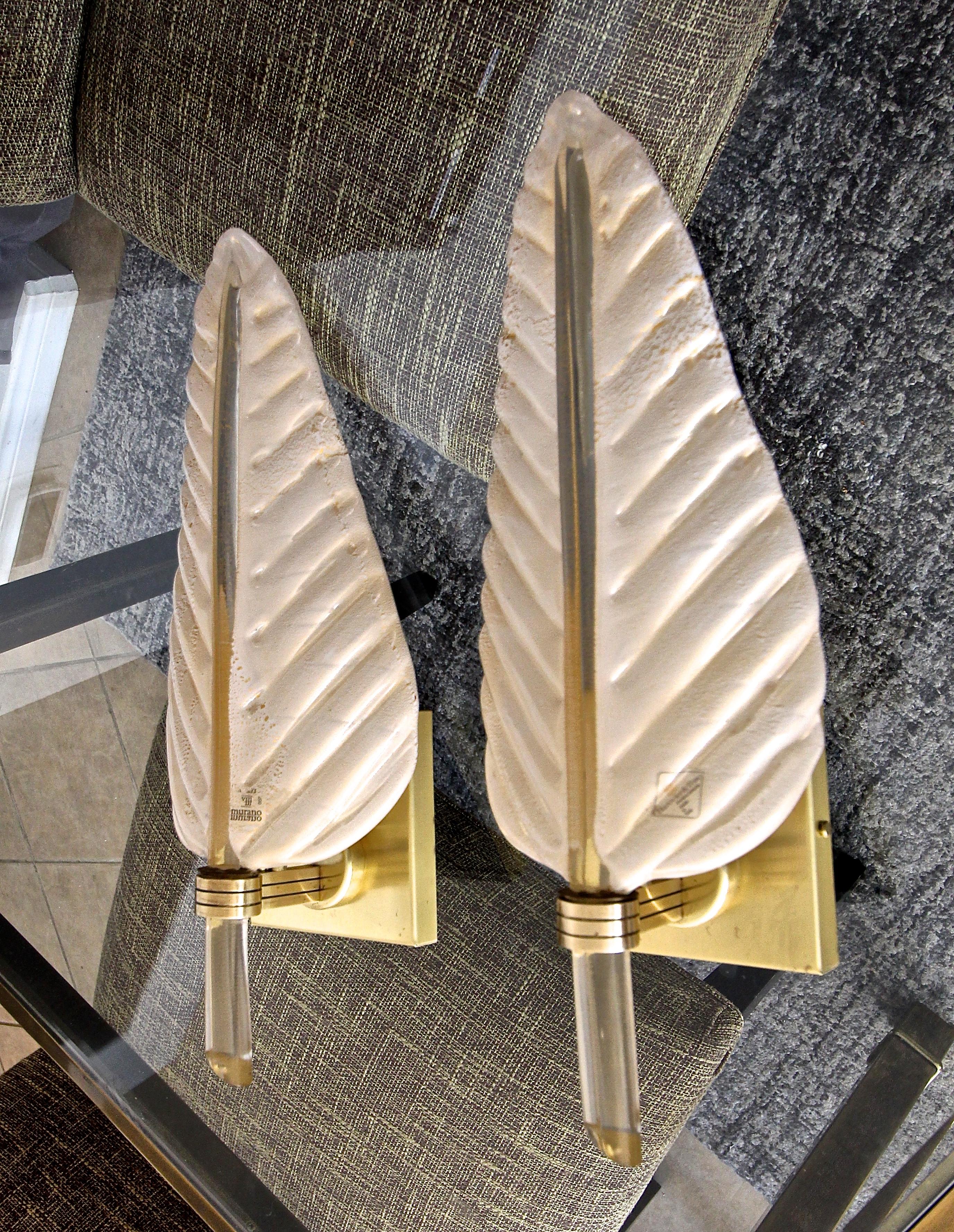 Pair of large Murano cream colored (off white) with gold infused glass wall sconces in plume or leaf form manufactured by Barovier & Toso. Each glass leaf is suspended on a brass backplate. Newly wired for US. Each sconce uses one candelabra base