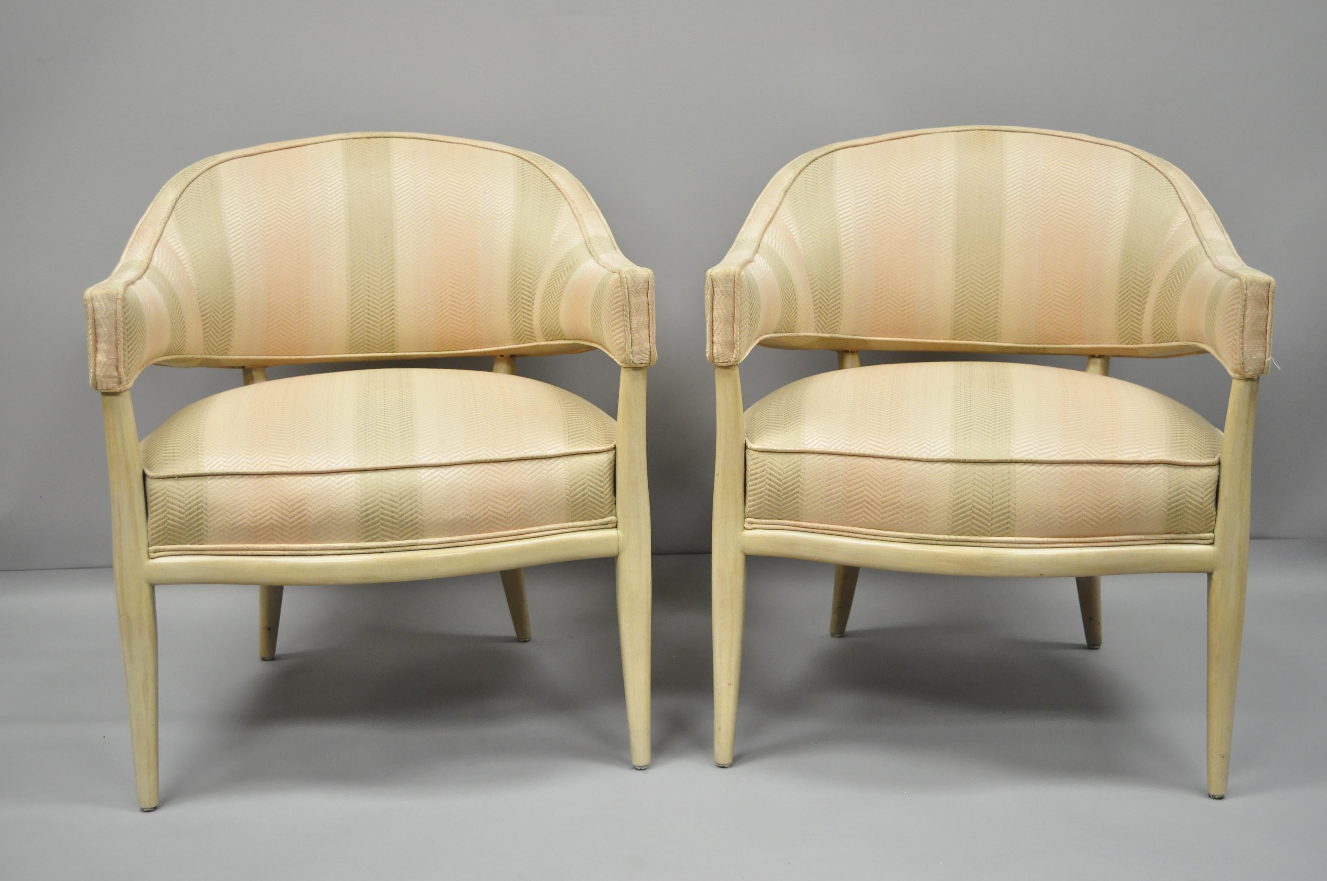 Pair of solid mahogany frame barrel back Mid-Century Modern lounge chairs with original white washed finish in the manner of T.H. Robsjohn-Gibbings. The chairs feature upholstered barrel backs, solid wood frames, shapely saber legs, and sleek