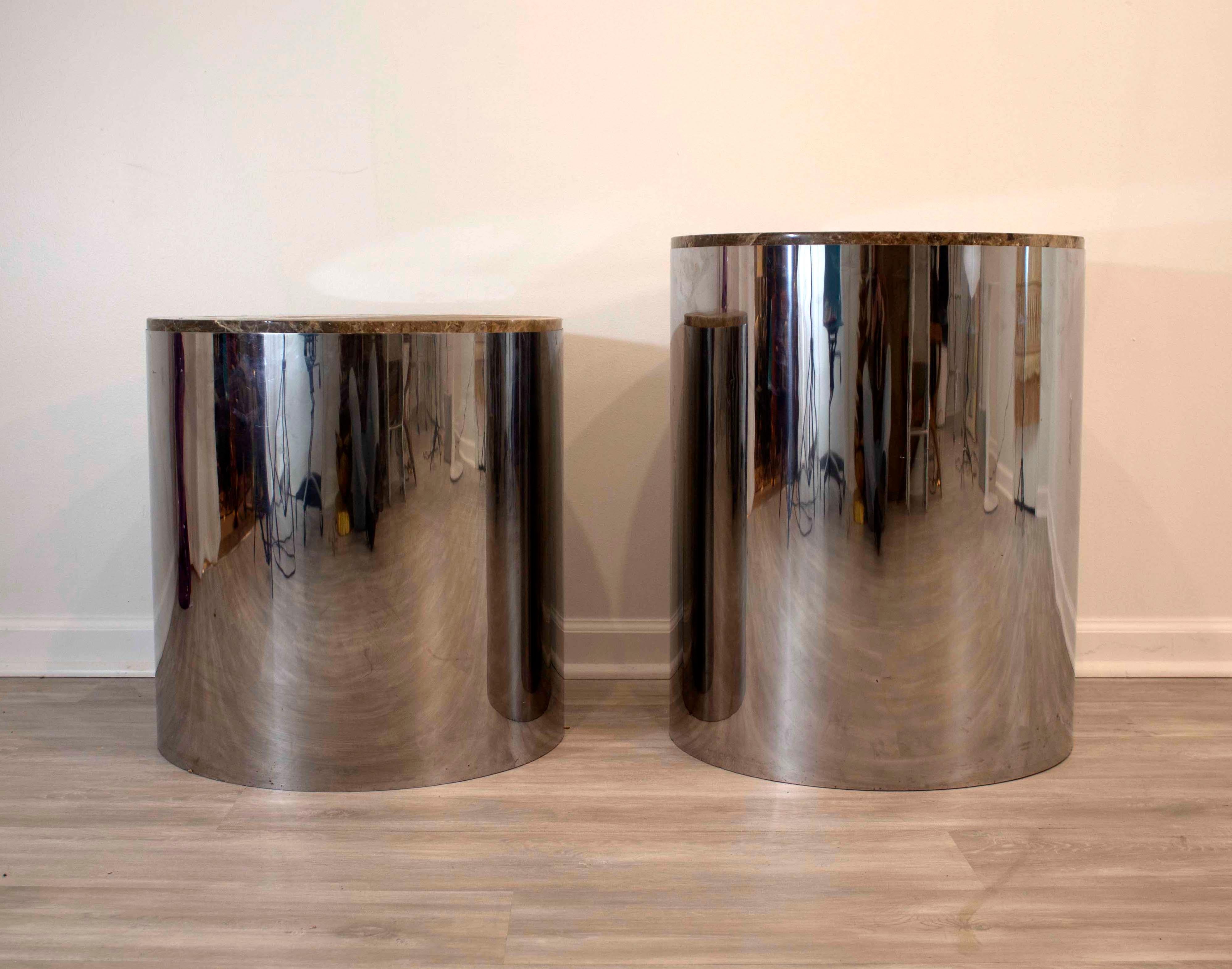 These Baughman style drum side and end tables, designed with a round, chrome base and rich marble top are in very good condition. This pair of differing heights could be used as side tables as well as pedestals for holding art or sculpture.

In