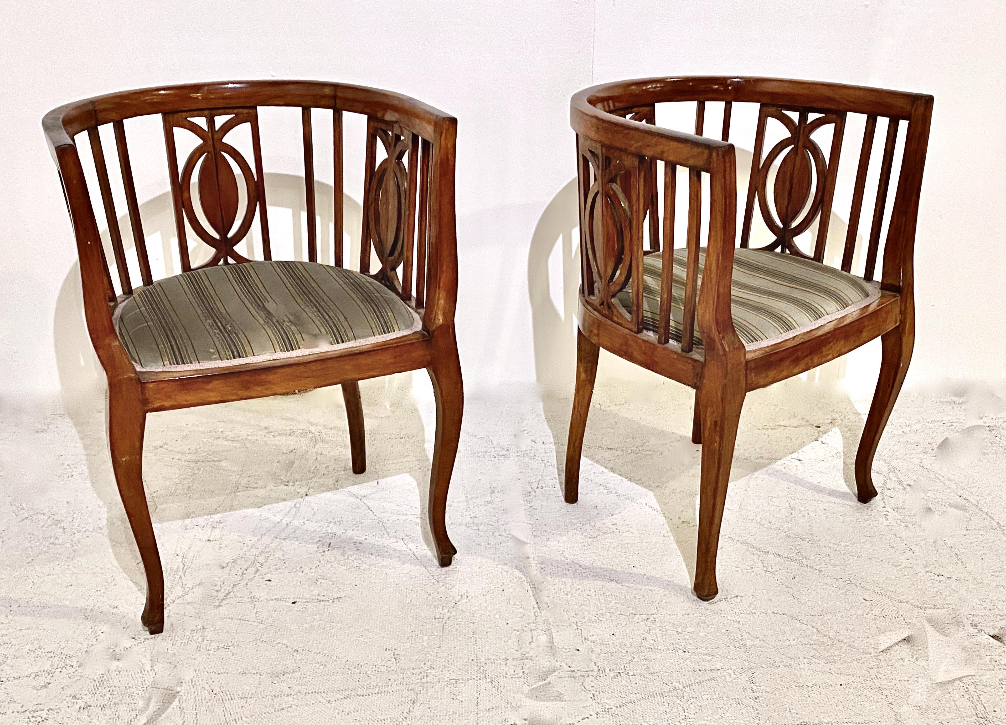 This is an unusual form of Biedermeier Barrel Back chairs in walnut. The barrel back is configured of open bars with three profiles of abstracted pineapple* silhouettes spaced between the bars. The abstracted form of the pineapple lends a lightness,