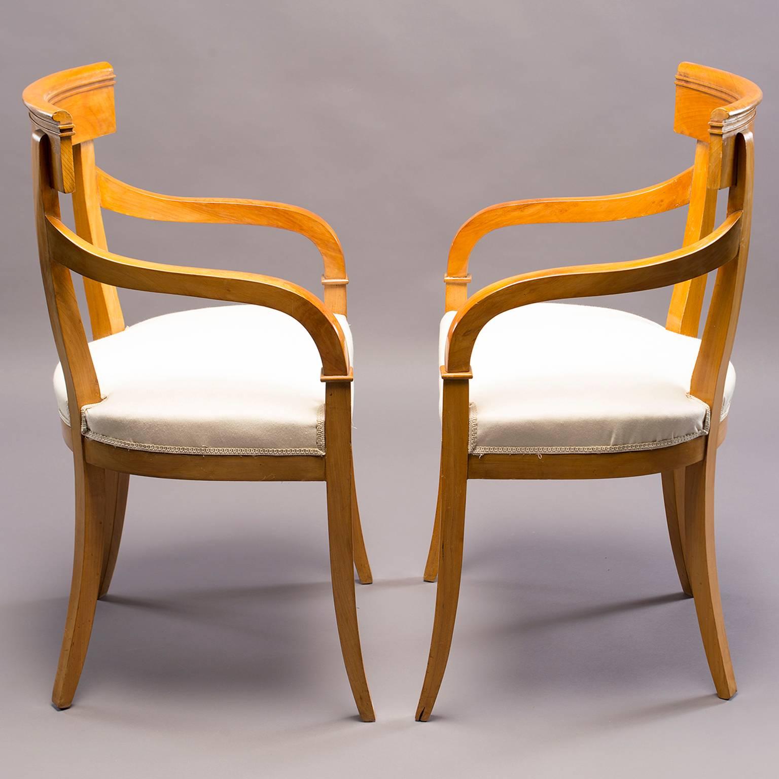 Pair of Biedermeier style armchairs with clean, simple lines in lighter wood believed to be birch, circa 1930s. Seats have muslin cover and are ready to be upholstered in fabric of your choice. Graceful curved arms are 25.75” high and seats are