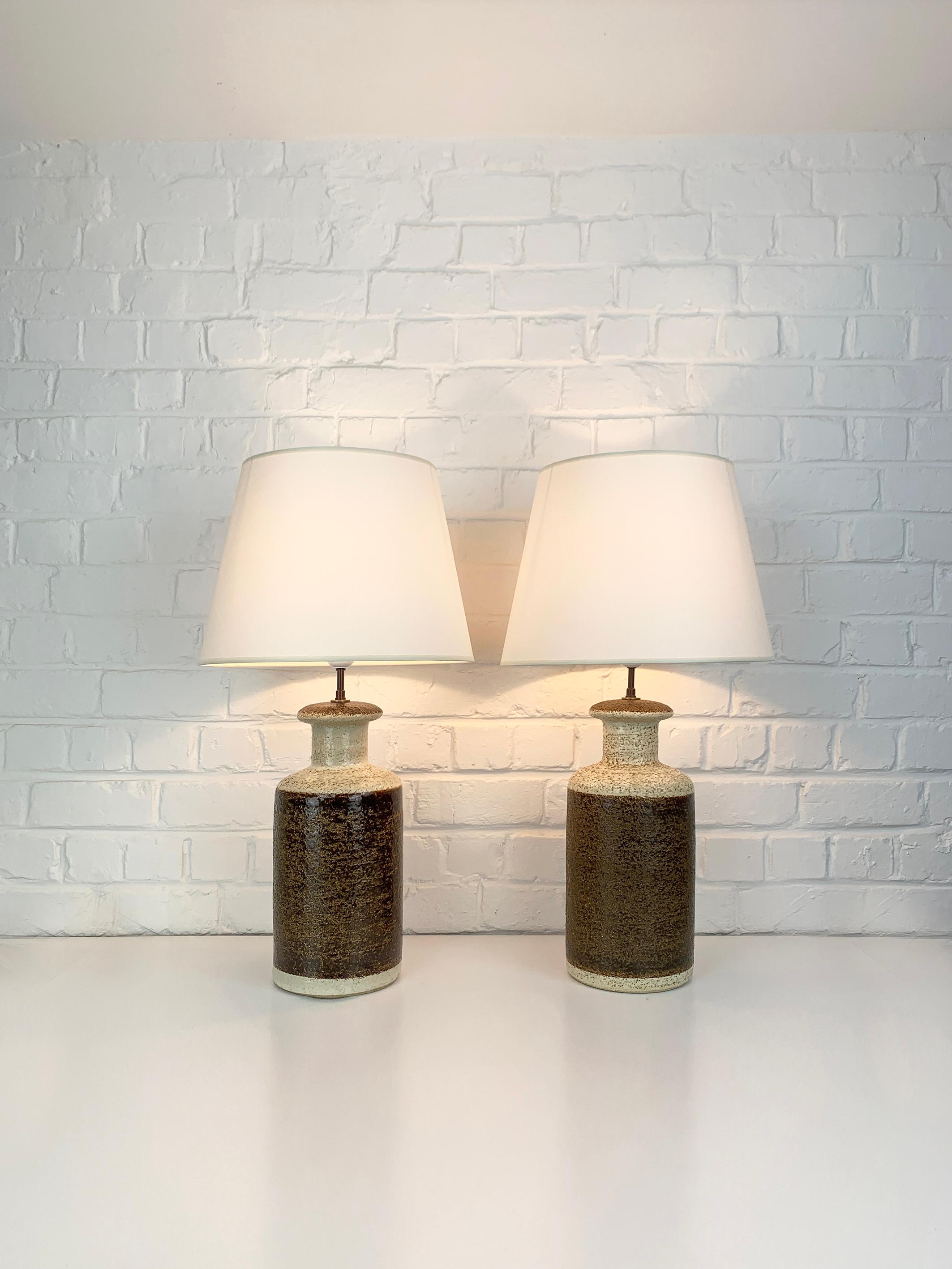 Pair of Danish Mid-Century stoneware table lamps of the 1970s, design by Svend Aage Jensen. 

Scuptural lamp bases made of chamotte clay with earth-tone glaze, chocolate brown and beige colors. These lamps exist in different sizes, here the biggest