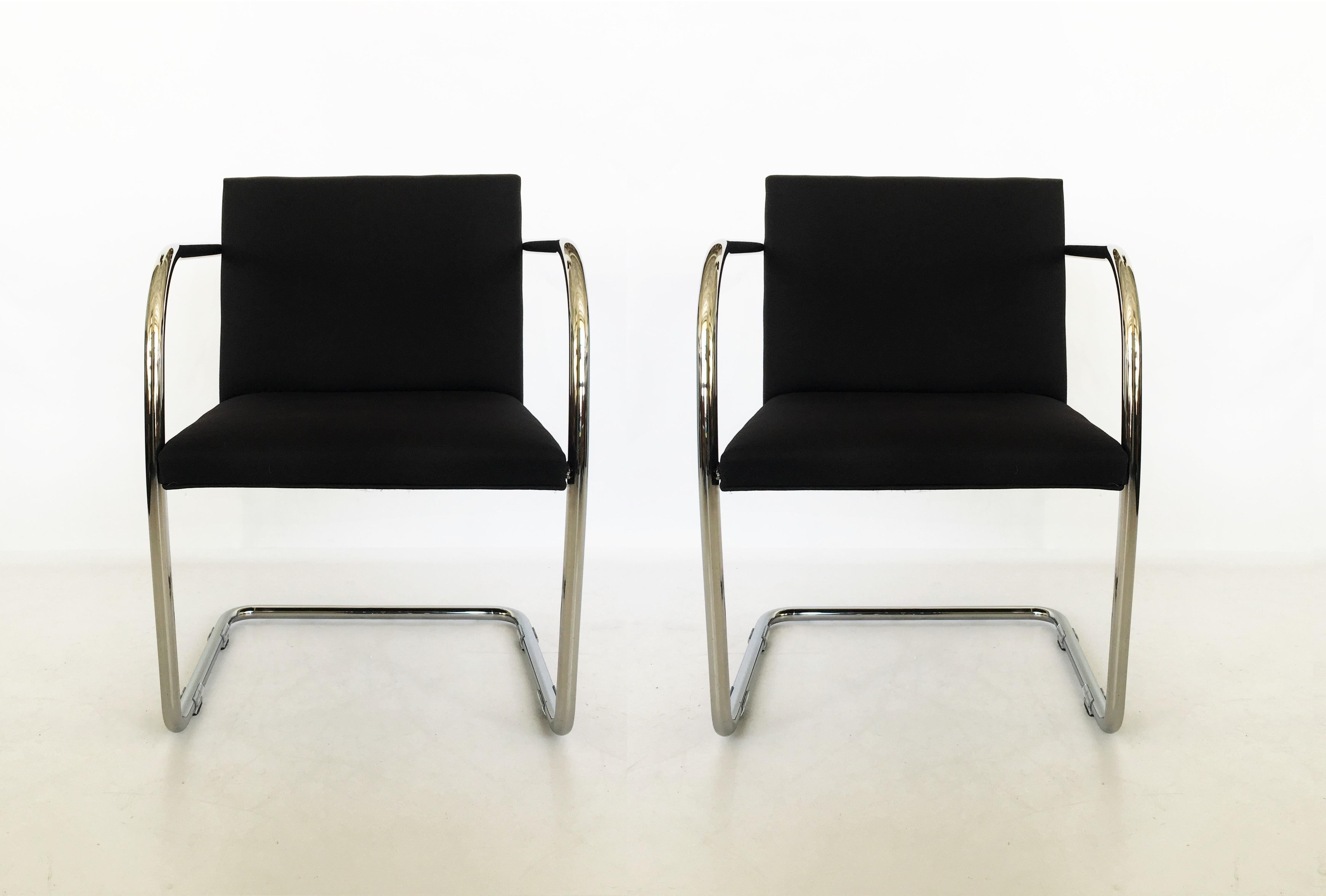 Classic Bauhaus design pair of Brno chairs by Mies van der Rohe for Thonet. The chairs feature polished chrome-plated tubular steel cantilevered frames, seats upholstered in a black fabric. One chair retains original label.