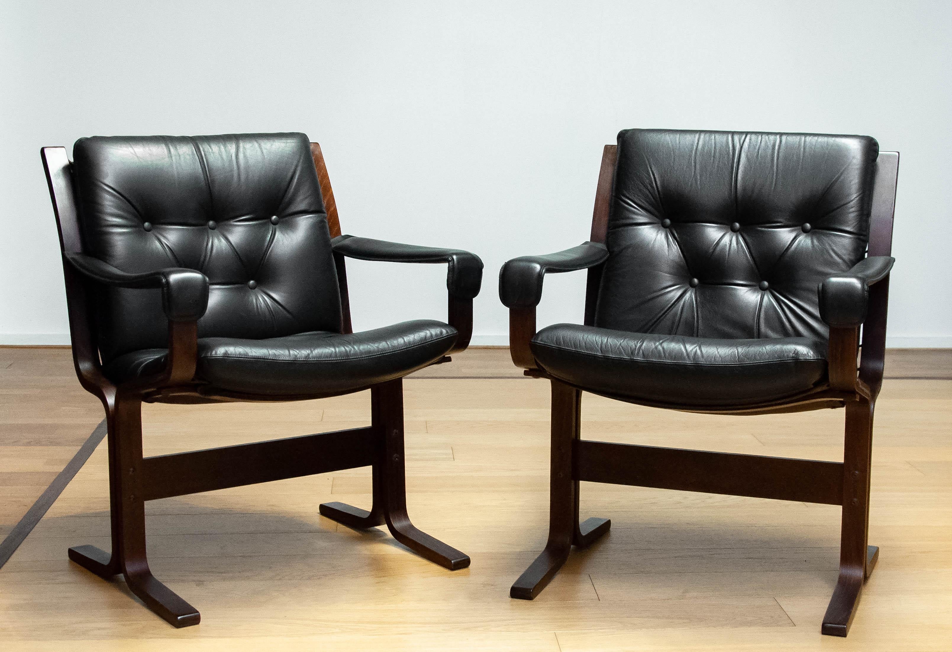 Beautiful and rare set of two, 1960s, black leather 'Siesta' dining  / office chairs designed by Ingmar Relling for Westnofa in Norway.
Both chairs tufted leather seats and backrests and leather upholstered armrests are in good condition as well as
