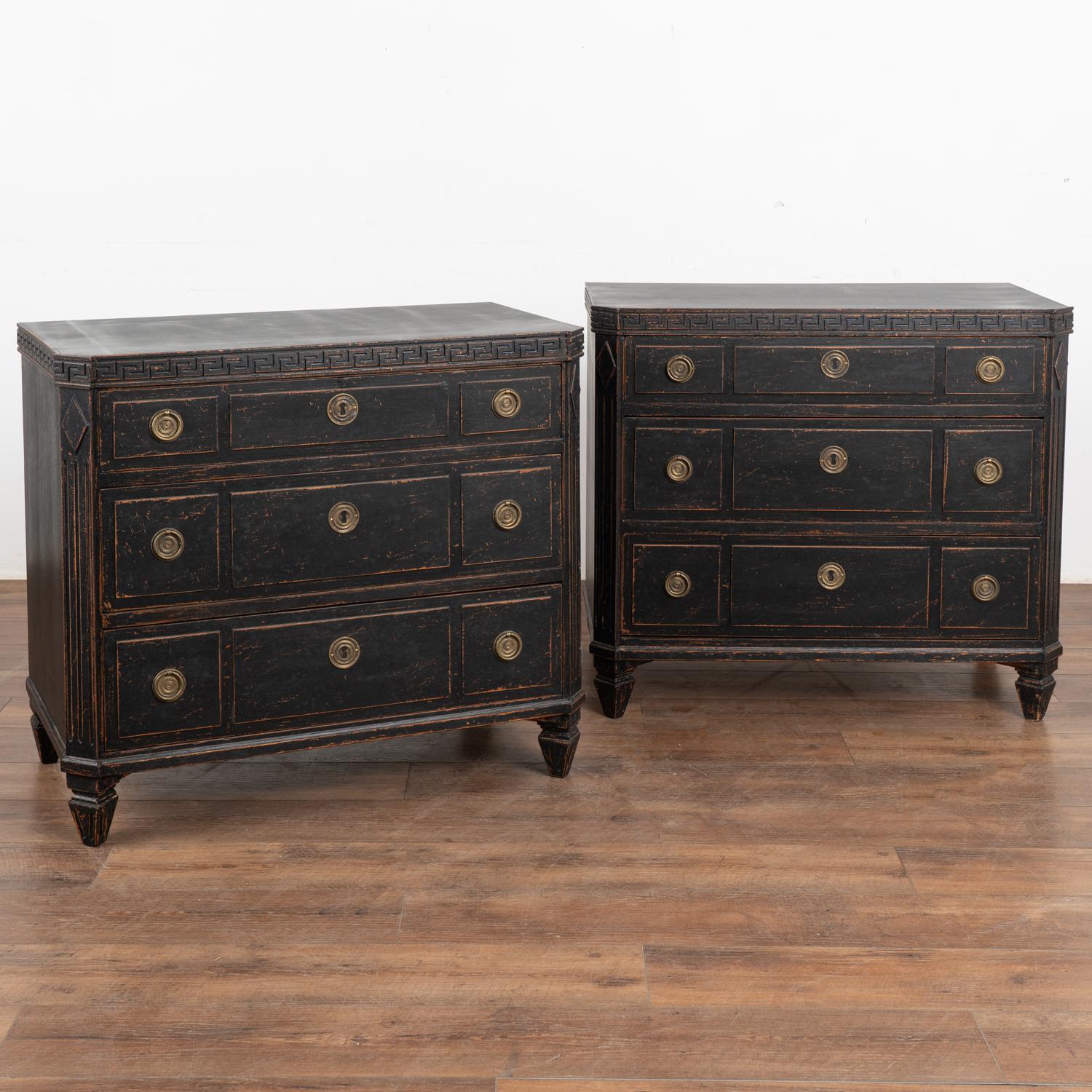 A pair of Gustavian pine chest of drawers with canted fluted side posts with upper carved diamond medallion and Greek key meander along top, all raised on four tapered fluted feet.
The newer, professionally applied layered black painted finish is