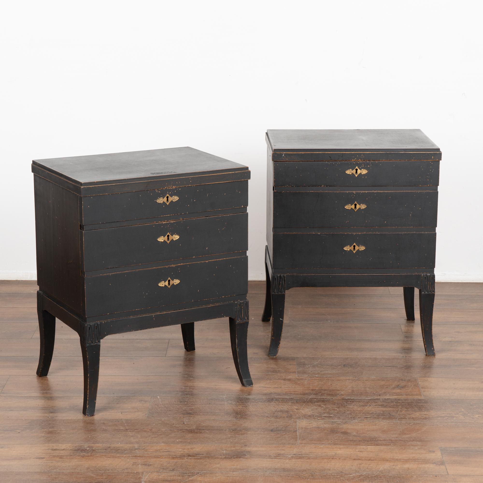 A pair of small Gustavian style pine chest of three drawers with clean tapered lines.
The newer, professionally applied black painted finish is perfectly distressed to fit the age and grace of this refined pair of nightstands. 
Restored and ready