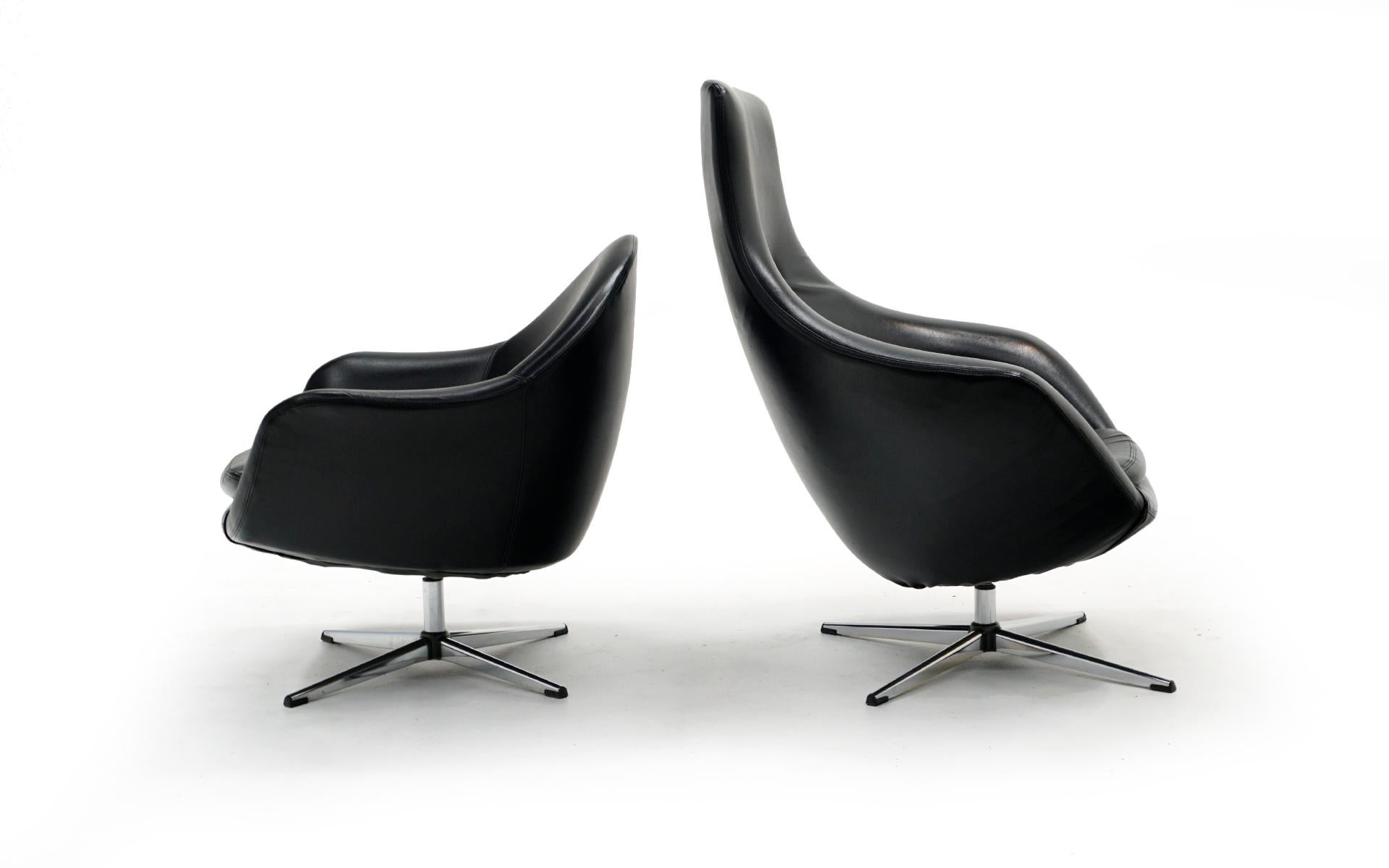 Pair of Overman black vinyl swivel chairs. Get the modern / mod look of high design at a fractioon of the price. Lightweight and easy to move these chairs are comfortable and very durable. The original black vinyl is in surprisingly good condition.