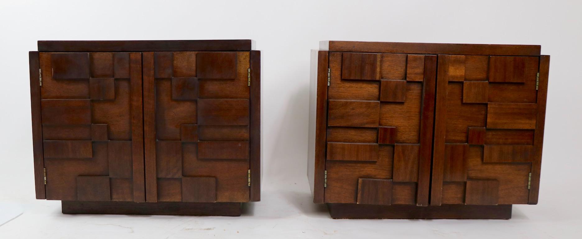 Chic pair of Brutalist style block front nightstands, Mosaic Line, manufactured by Lane. Each stand has two doors which open to reveal shelved storage. These are walnut veneer, with a dark tone finish. Both are in clean, original, ready to use