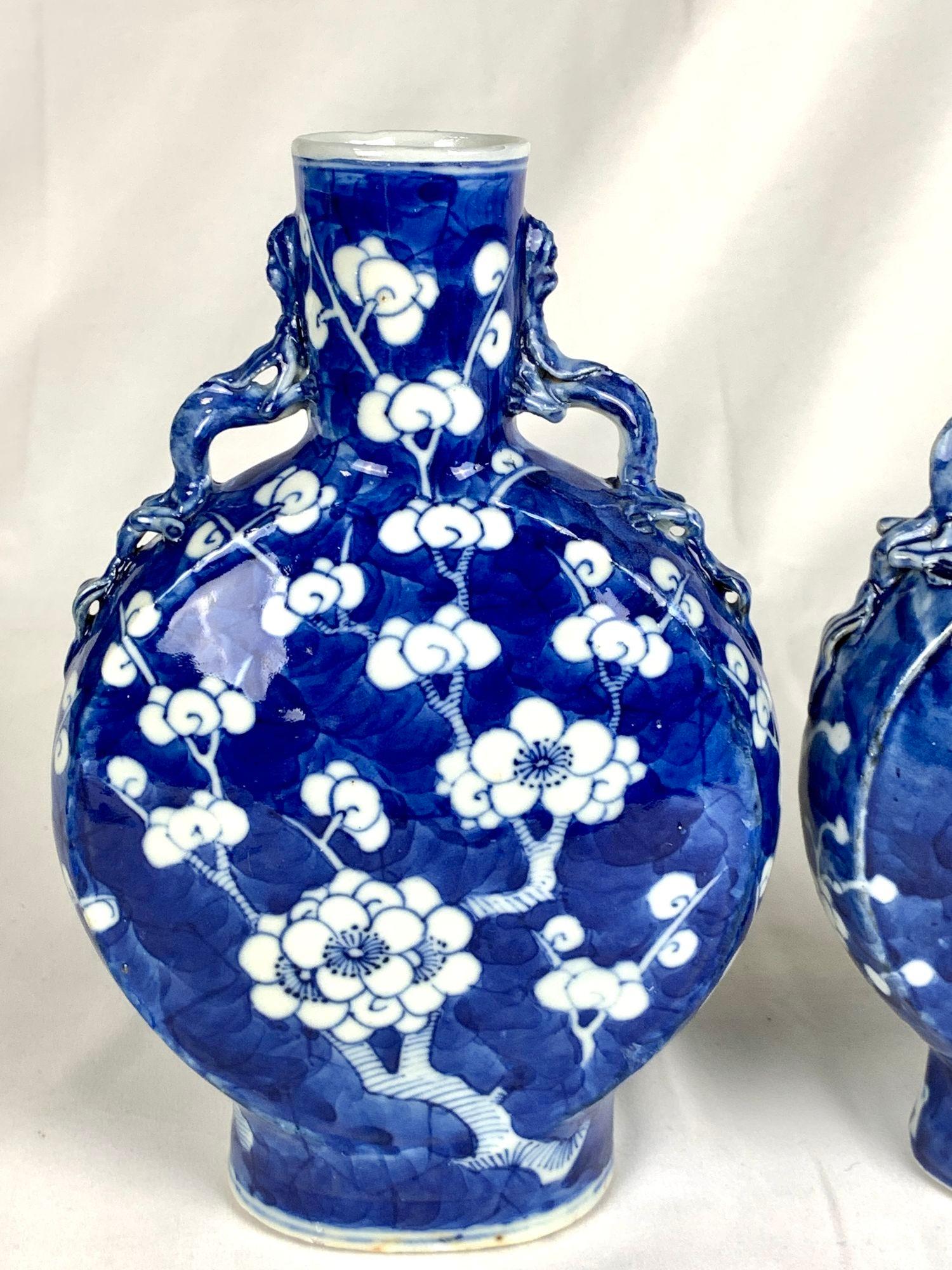 This pair of Chinese porcelain moon flasks are hand painted with lovely white plum blossom flowers on a deep cobalt blue ground.
They were made in the late 19th century during the Qing Dynasty transitional Guangxu period, circa 1880.
The harmonious