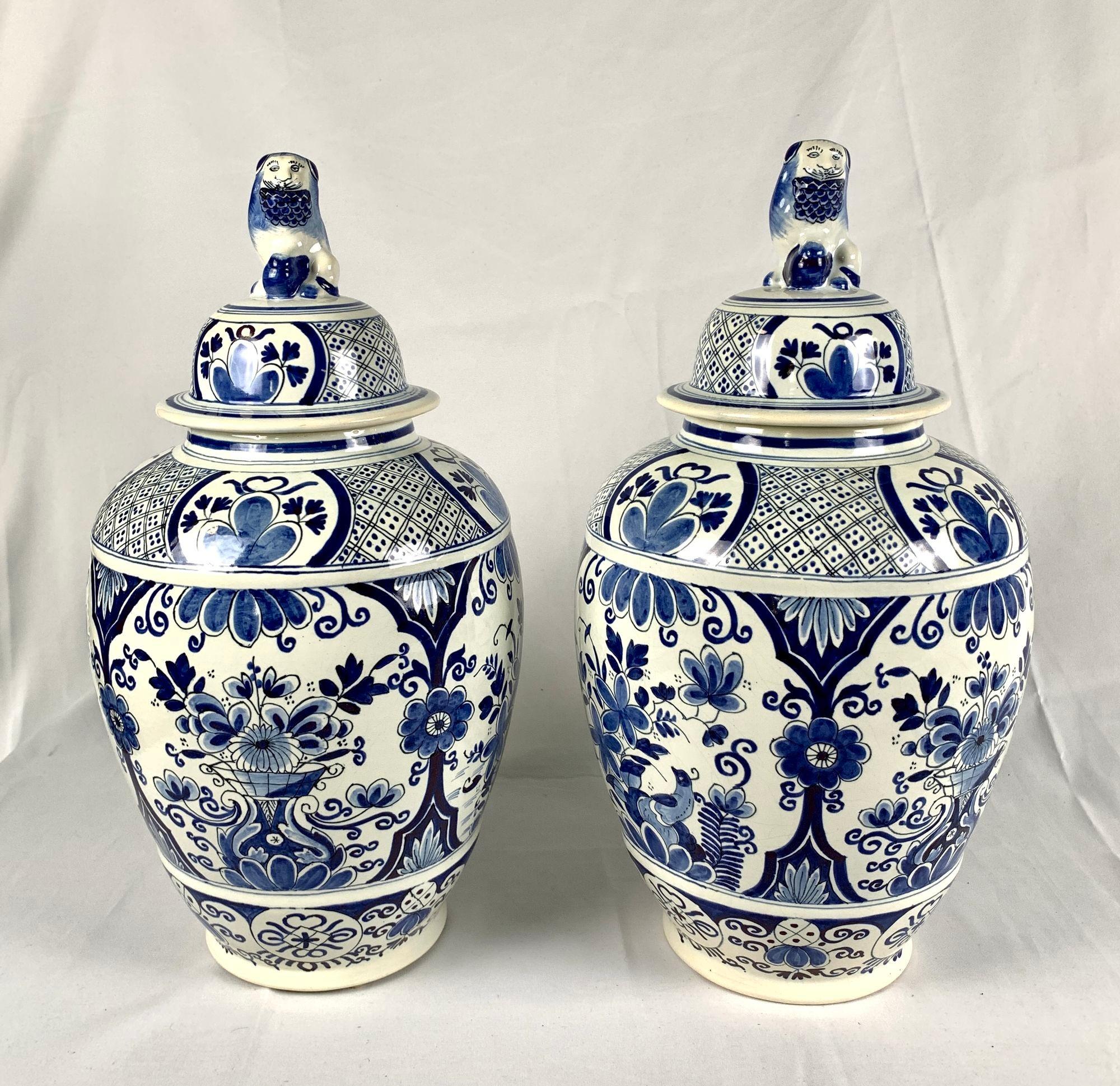 This pair of large Delft jars has a traditional blue and white floral decoration painted on a white tin-glazed ground.
The body of each jar features four large panels; two show a peacock among flowers, and two show a vase overflowing with