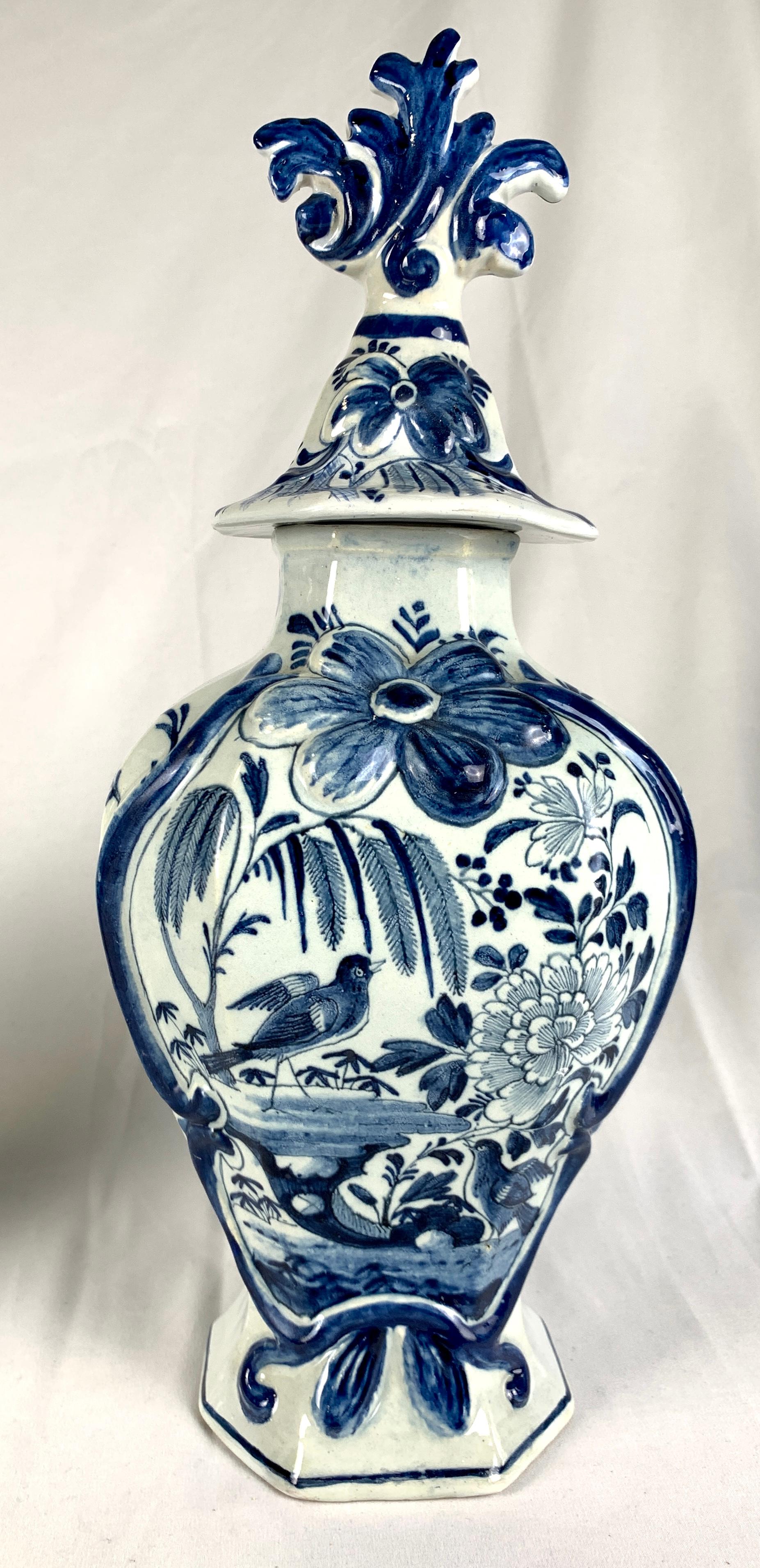 This pair of blue and white Delft mantle jars were hand painted at De Porceleyne Lampetkan factory circa 1770.
They are gorgeous! 
We see songbirds in a garden with a weeping willow tree and a large peony in full bloom.
The garden scene is framed