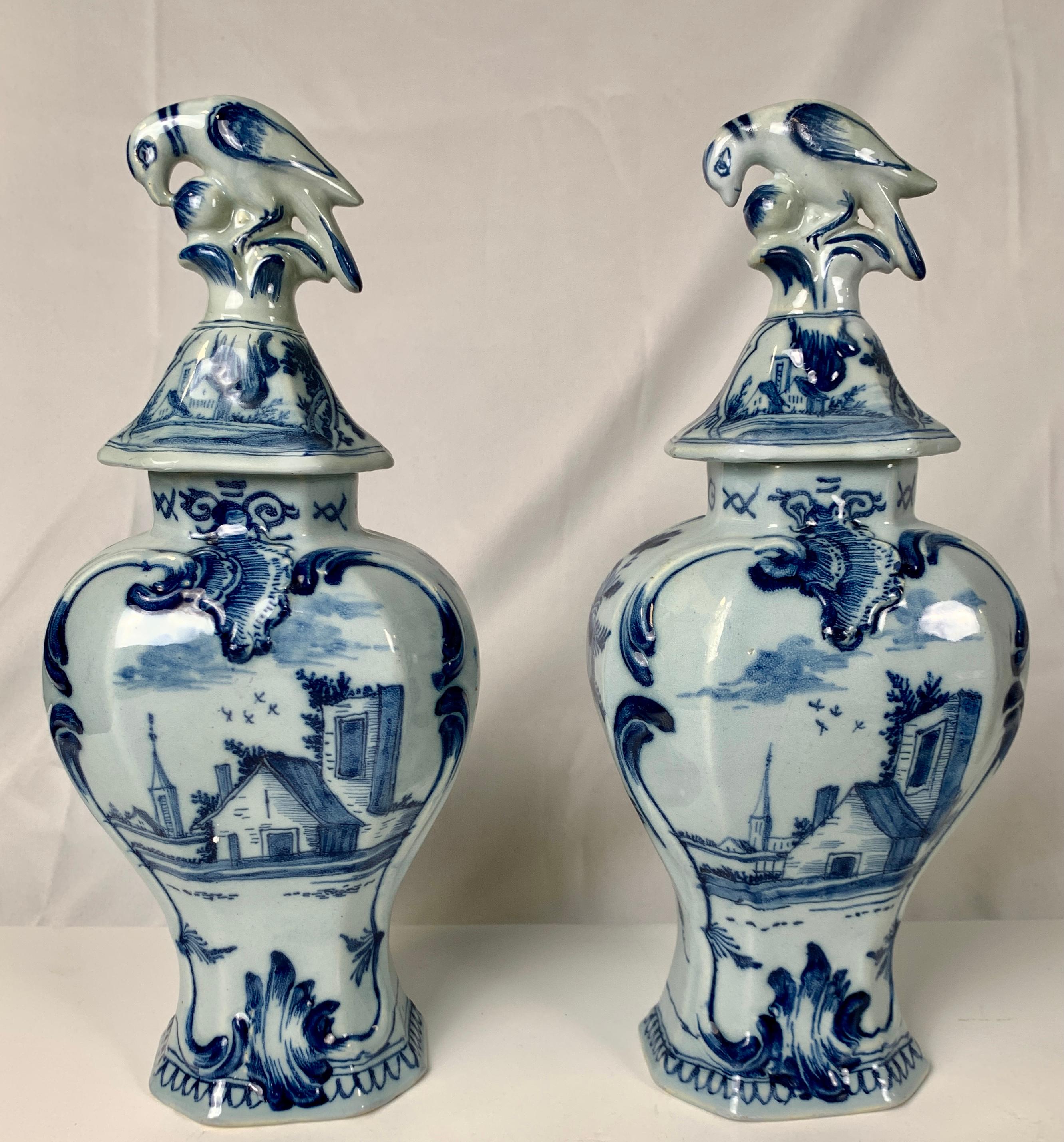 This pair of blue and white Delft mantle vases was hand-painted in shades of cobalt blue in the 18th-century circa 1780. The lovely romantic scene on the front of our vases shows a pair of lovers in a garden (see images). The couple stands in the