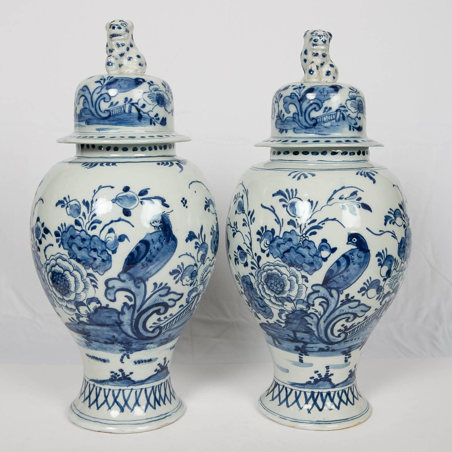 A pair of blue and white Dutch Delft mantle jars painted with
an all around scene showing a songbird in a garden
filled with peonies. The cover is similarly decorated and topped
by a whimsical leopard finial.
Dimensions 15 inches tall x 7 inches
