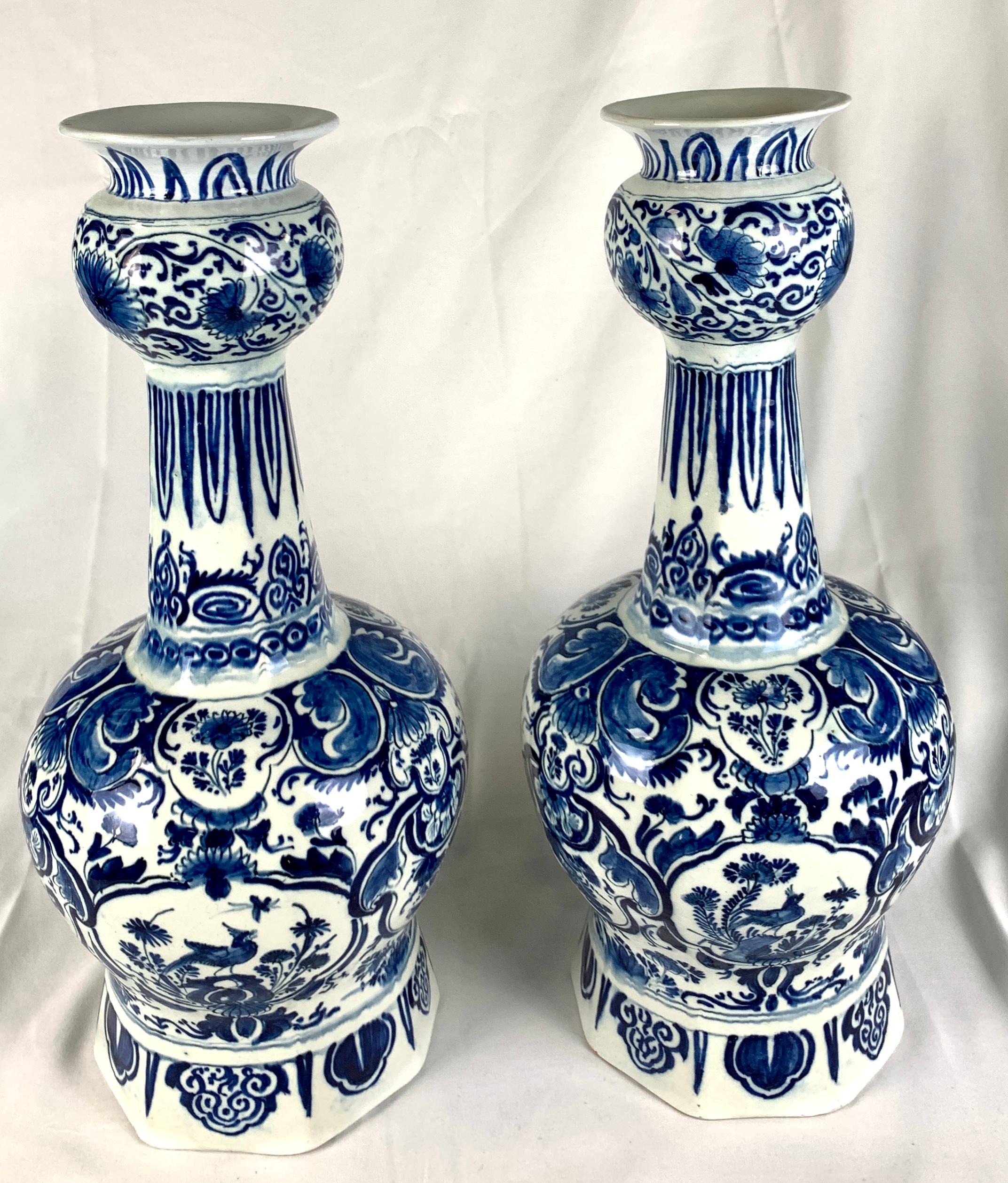 This large pair of blue and white Dutch Delft vases were hand painted in beautiful deep cobalt blue. They were made in The Netherlands in the 18th century, circa 1770.
The main body of each vase is fully decorated with six cartouches, three showing