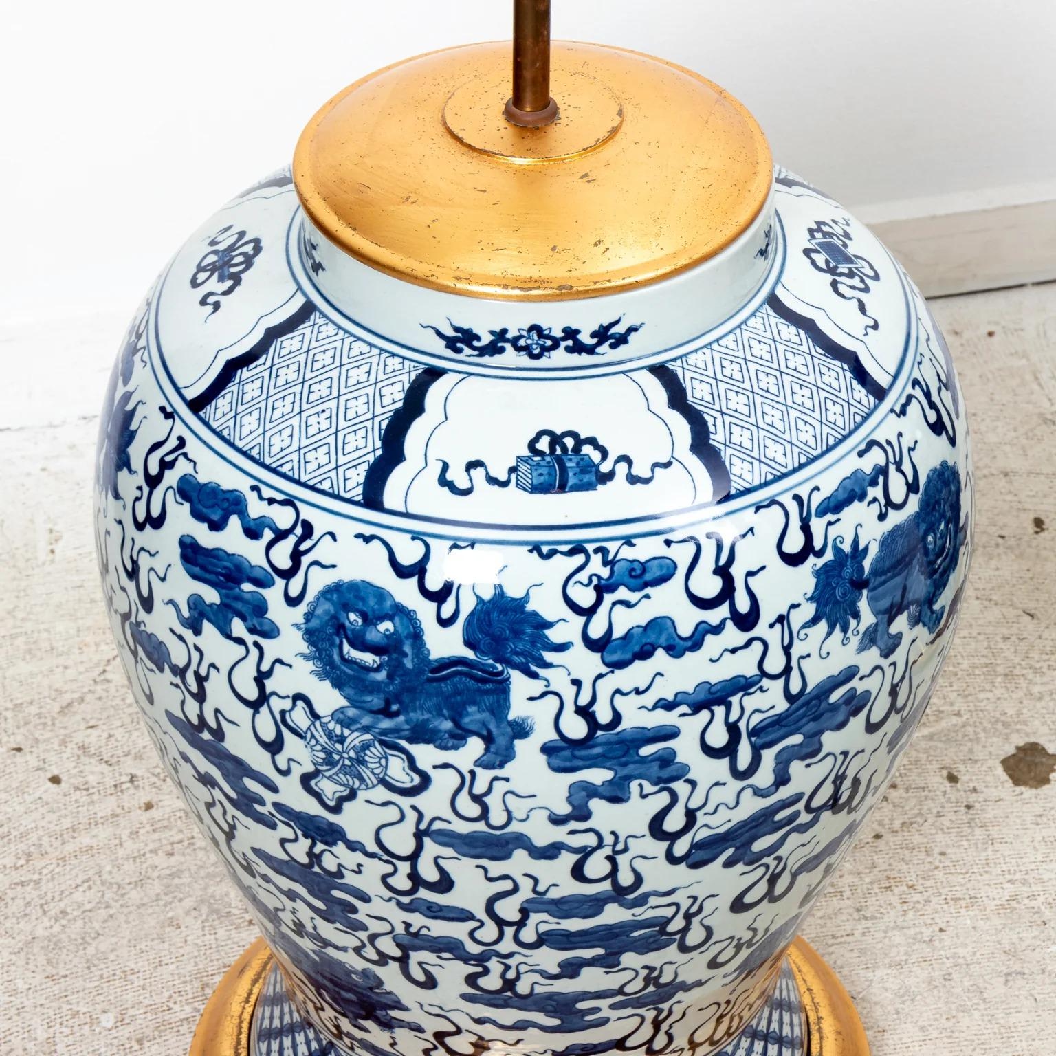 Pair of Chinese blue and white temple jars mounted as lamps with giltwood bases and caps. 39