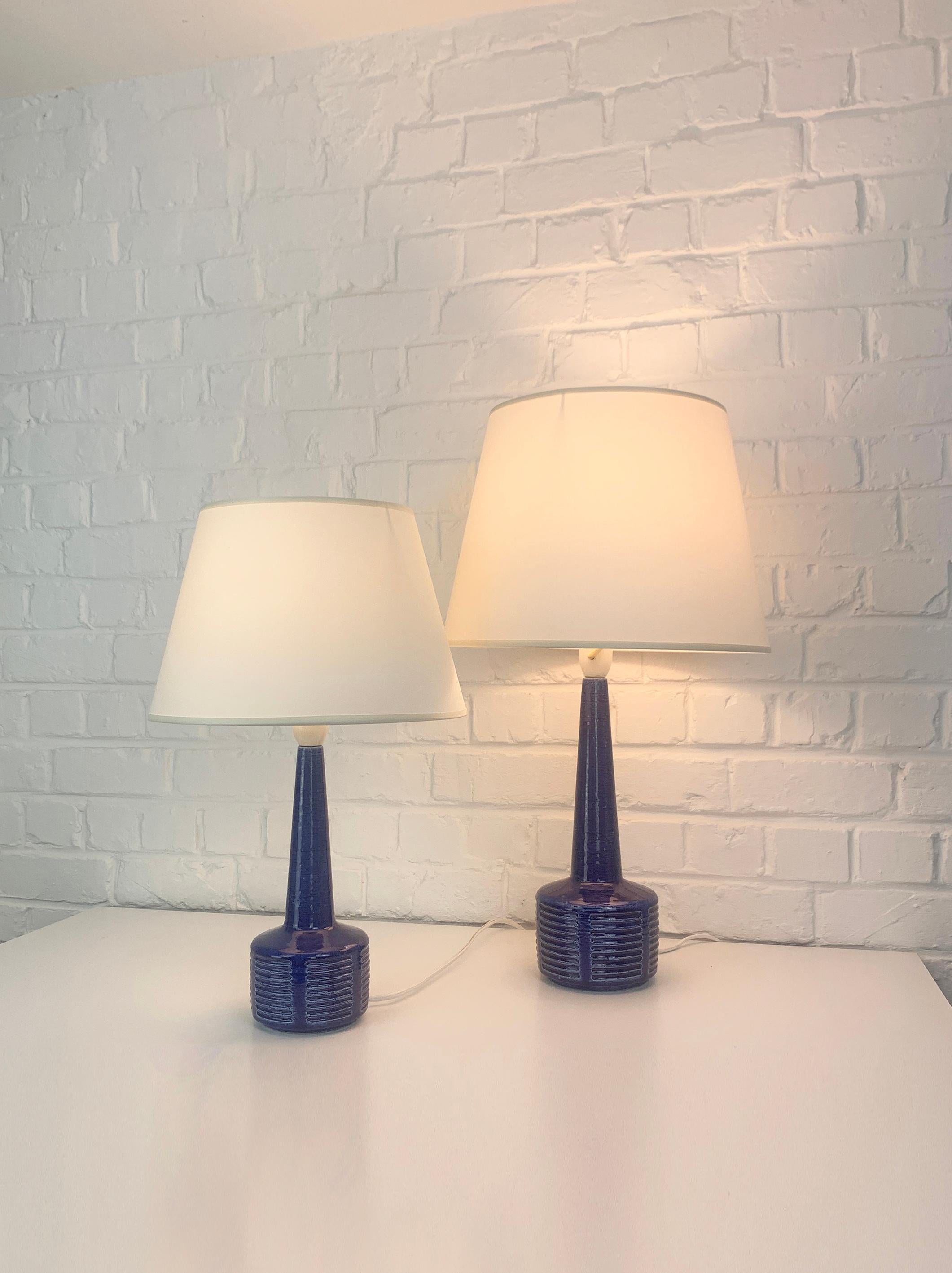Pair of stoneware table lamps, model DL34 and DL35, produced by Palshus (Denmark). 

The lamp bases are finished with a blue glaze and an impressed pattern. The chamotte clay gives a natural and living surface. Both are signed under the base (PLS