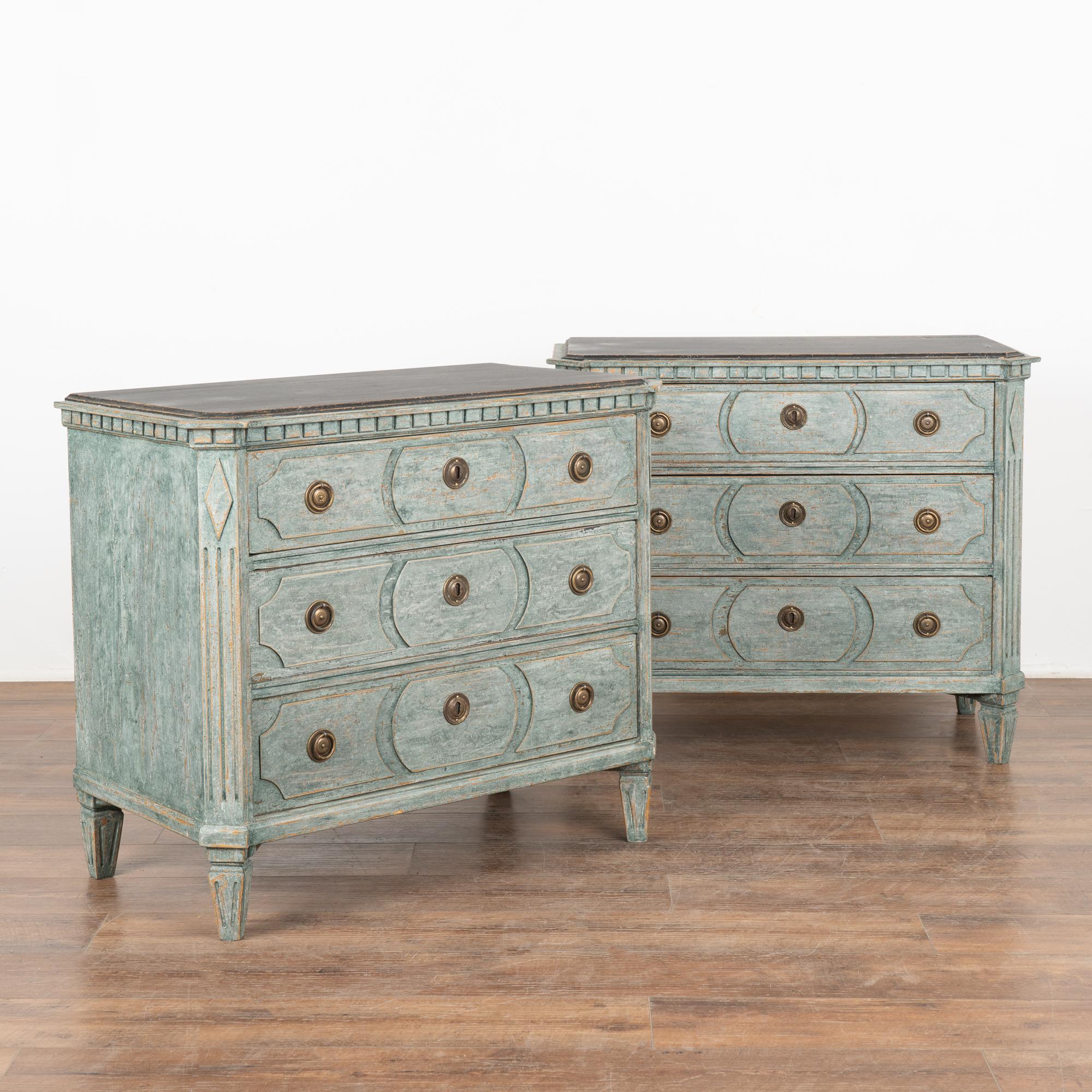 A pair of decorative Gustavian pine chest of drawers with canted fluted side posts with upper carved diamond medallion and dentil molding. All resting on four tapered fluted feet.
The newer, professionally applied layered blue (with soft white
