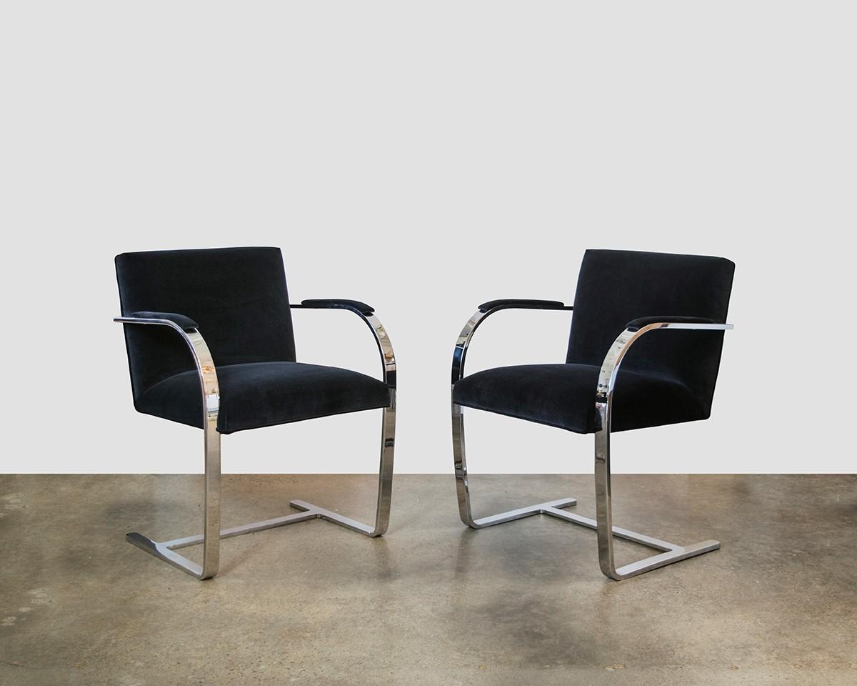 These vintage modern Brno flat bar chairs are sleek and timeless. Chairs feature cantilevered, heavy stainless steel flat-bar frames. The seat, backrest and the arched armrests newly re-upholstered in a luxurious blue velvet. Designed for multi-use