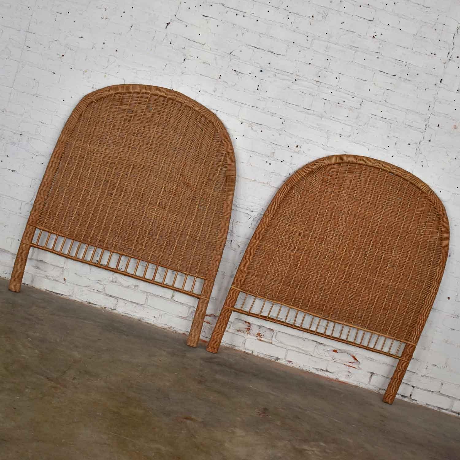 Charming pair of boho chic organic modern twin wicker headboards. Beautiful vintage condition. The wicker of the arched headboards has flexed a little over time as you would expect with use and wear. We have done some minor repair on a bit of the