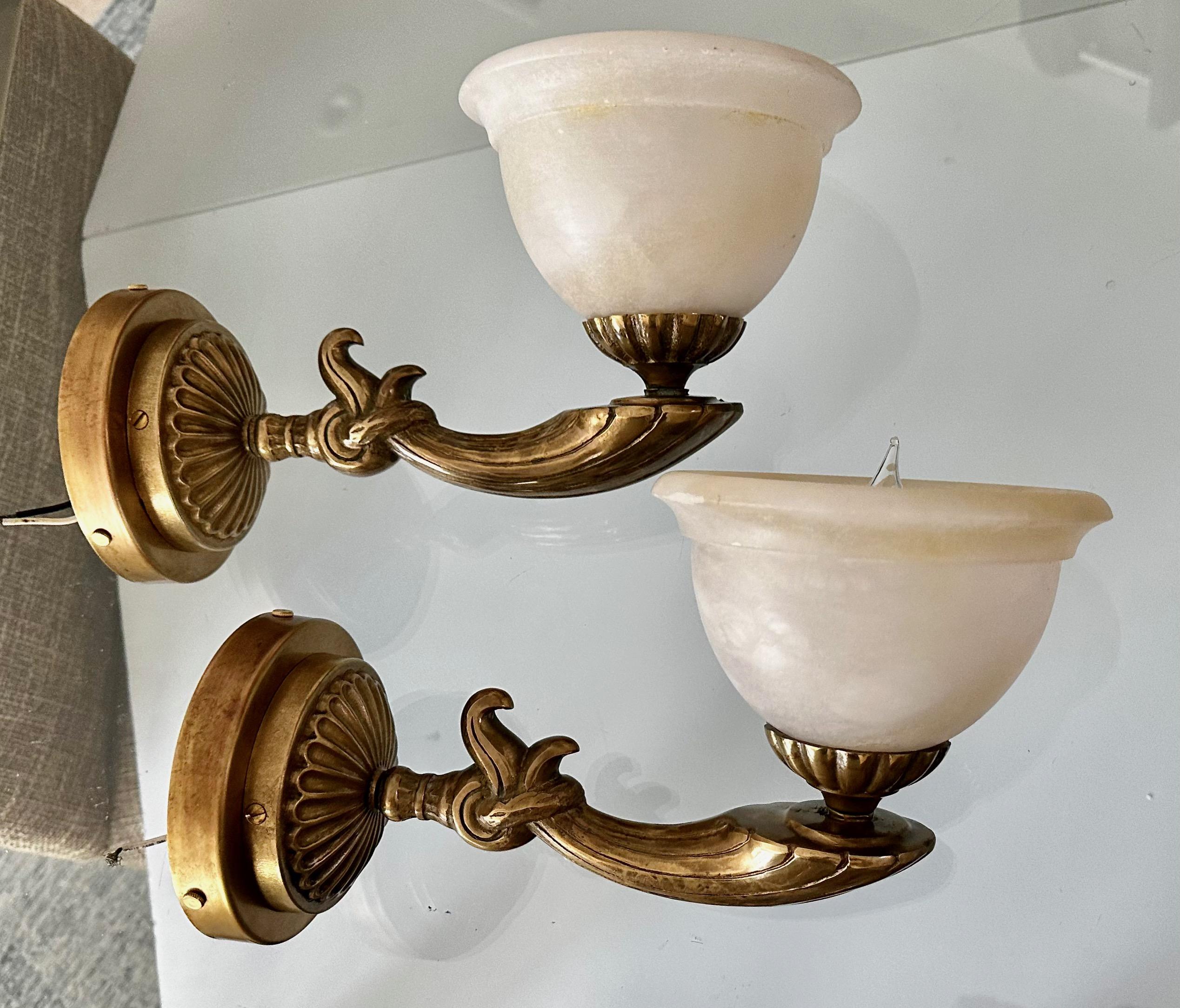 Pair brass French style wall sconces with alabaster globe shades. Each uses single regular A base bulb. Diameter of alabaster bowl 8