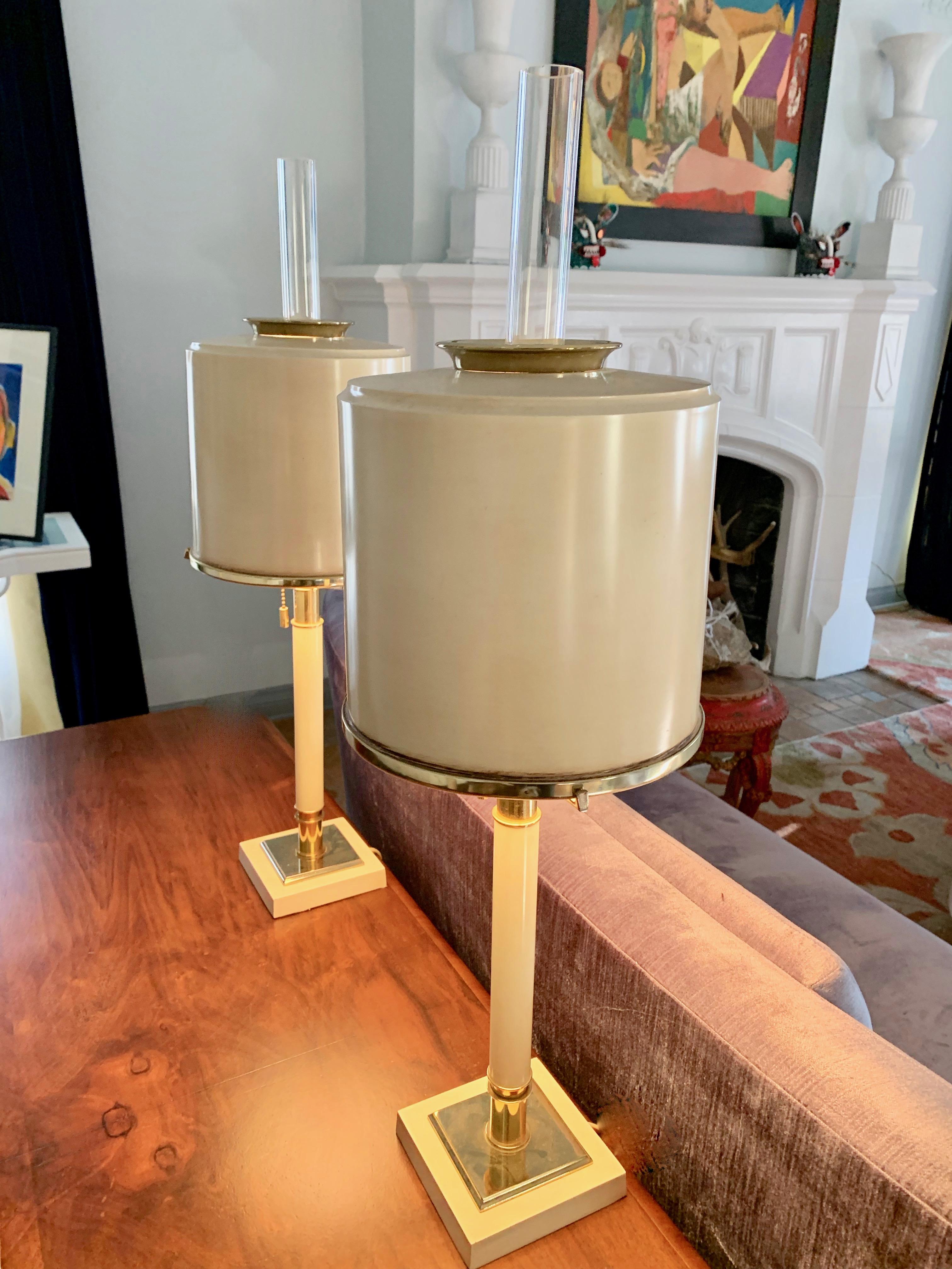 A wonderful modern pair of midcentury lamps by Laurel Lamp Company. 

The handsome pair are a cream colored metal with brass details and a three prong support for a dome of metal and finials in thick tubular glass. Great for any room. Laurel is