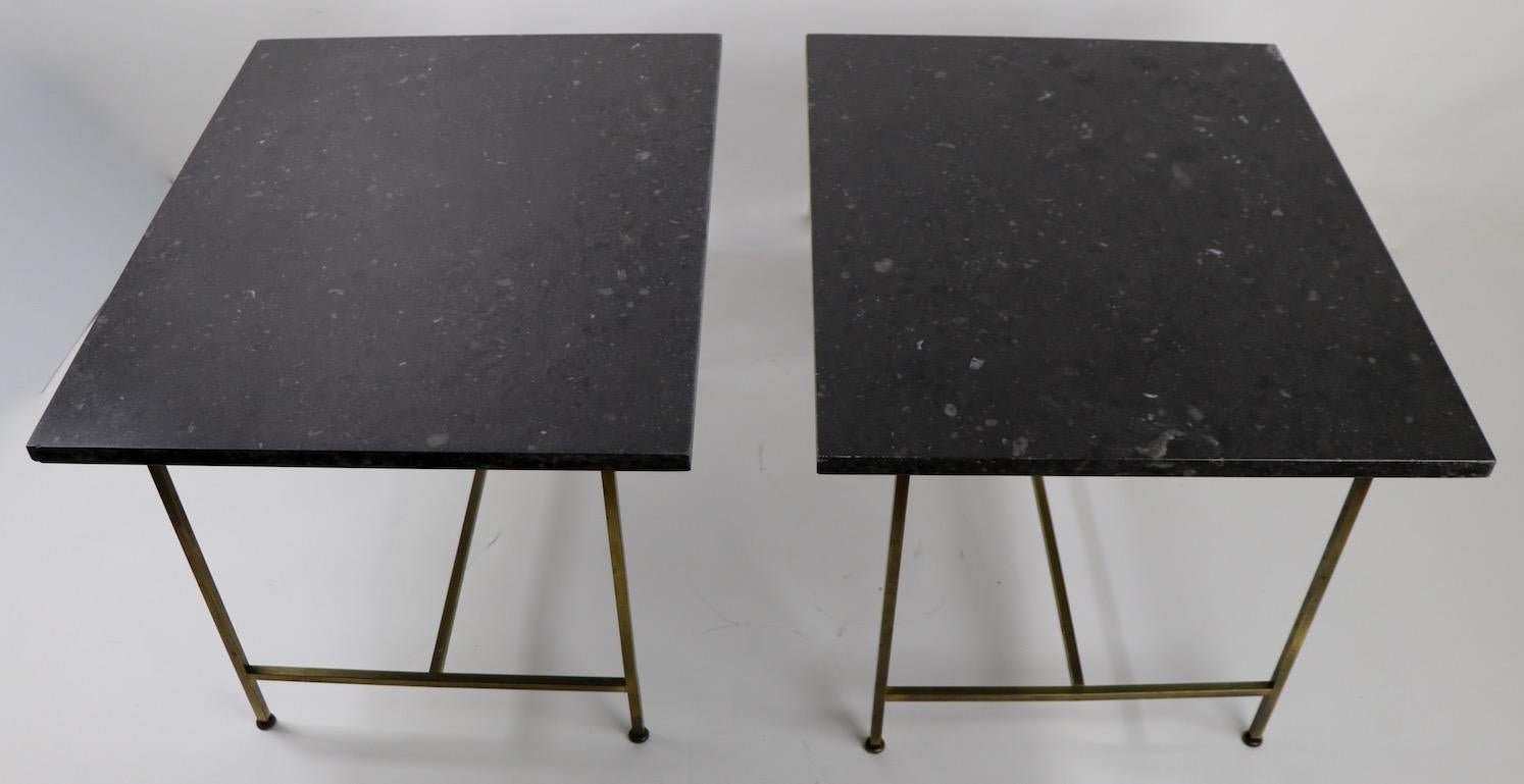 Pair of end, or side, tables by Paul McCobb having rectangular black marble tops and squared brass bases. Very good original condition, showing only minor cosmetic wear, normal and consistent with age. Tops 1 inch thick.