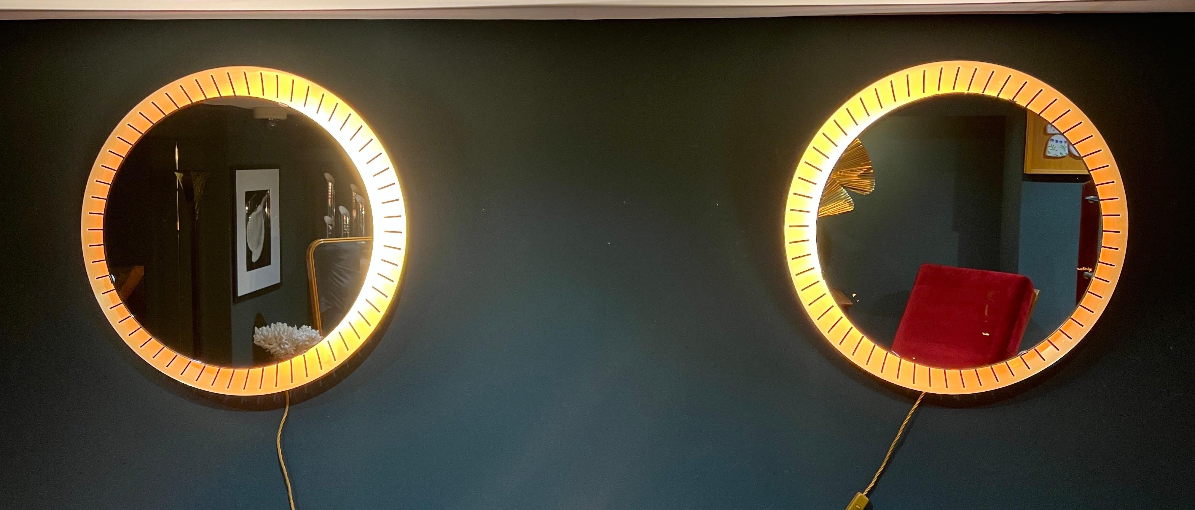Ein fantastisches Paar Messing hinterleuchteten Spiegel neu mit warmen dimmbaren LED-Streifen verkabelt. Perfekt für den Einsatz in Schlafzimmern, Bädern oder einfach als Wandleuchten. 
Hergestellt in Deutschland C1960s . 
Durchmesser 65cm