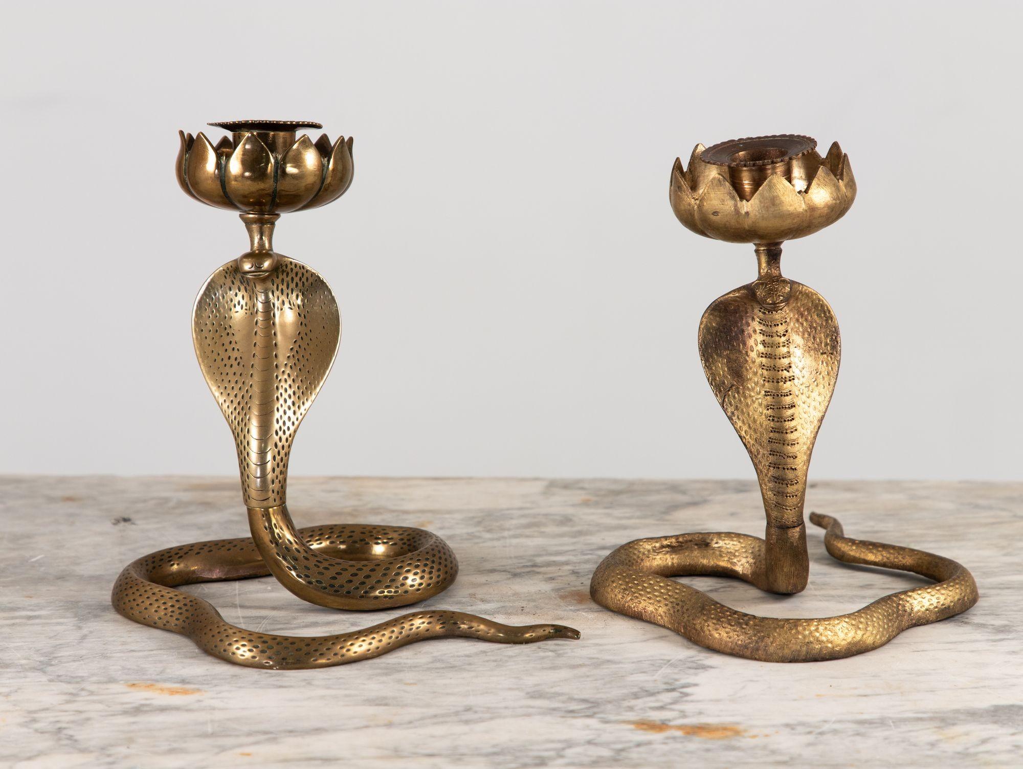 These exquisite brass candlesticks embody the captivating allure of the cobra. Standing proudly at a height of 8 inches, each candlestick is a masterful work of art crafted with stunning attention to detail. The sinuous bodies of the cobras coil