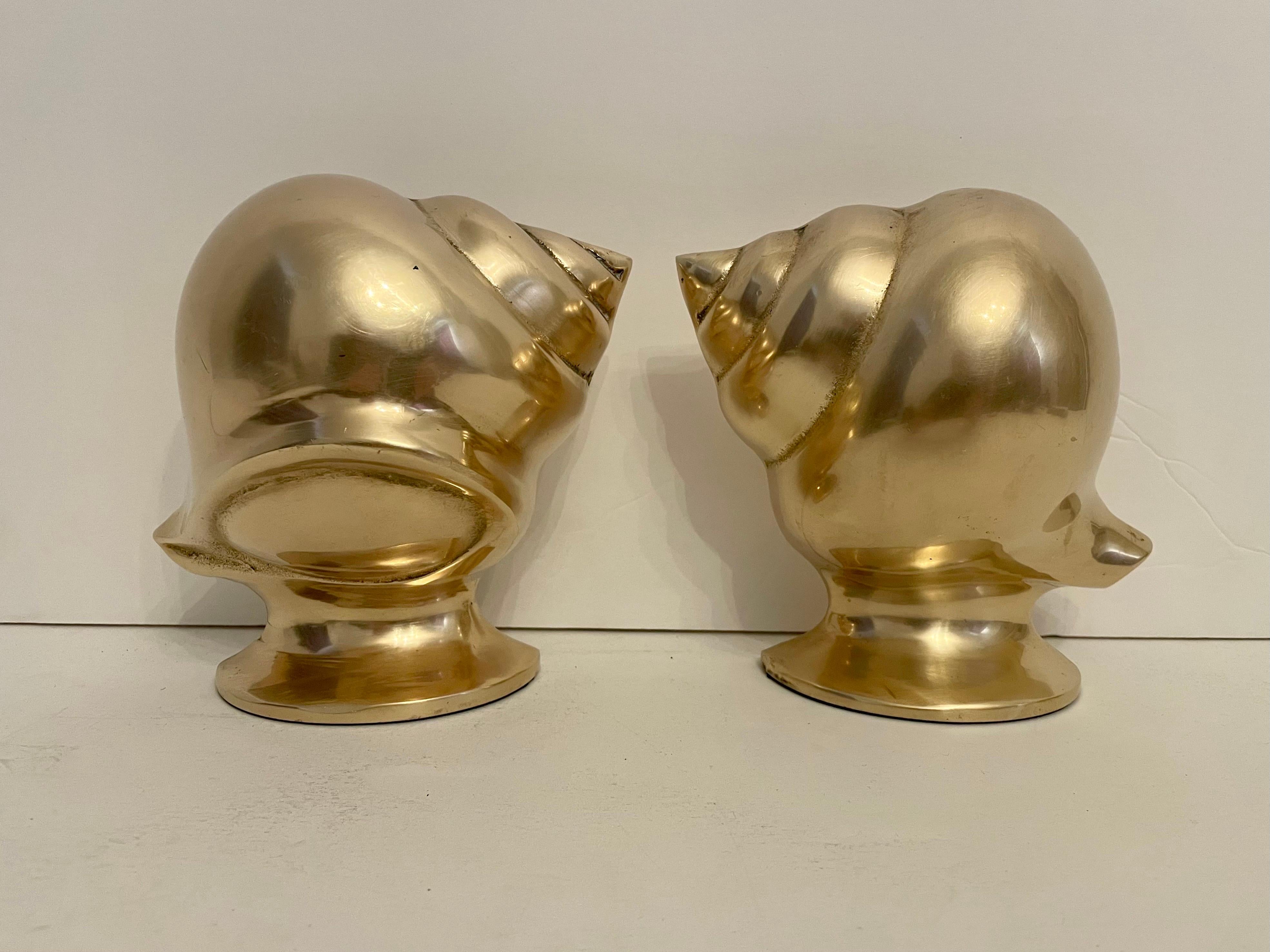 Brass nautical conch shell bookends. Nice detail in casting, heavy weight with substantial feel. Holds a shelves worth of books. Good condition, some slight patina. Thin pad on bottom to protect surfaces. Any dark or light spots are reflection only.