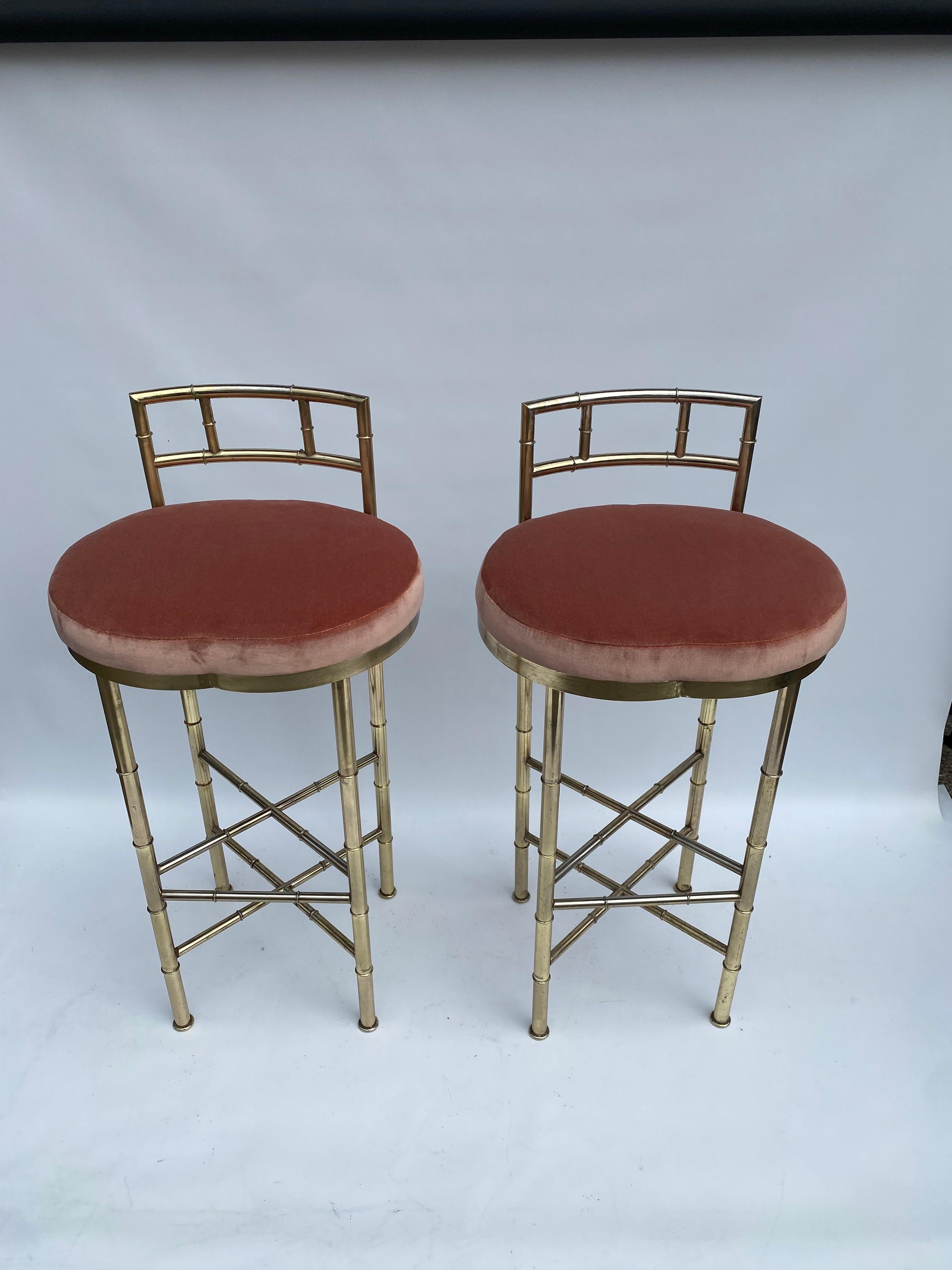 Impresionante par de taburetes de bar italianos de los años 70, chapados en latón, con estructura de imitación de bambú y respaldo. 
Los generosos asientos, con reminiscencias de melocotón, acaban de tapizarse en tela de algodón rosa Dedar, lo que