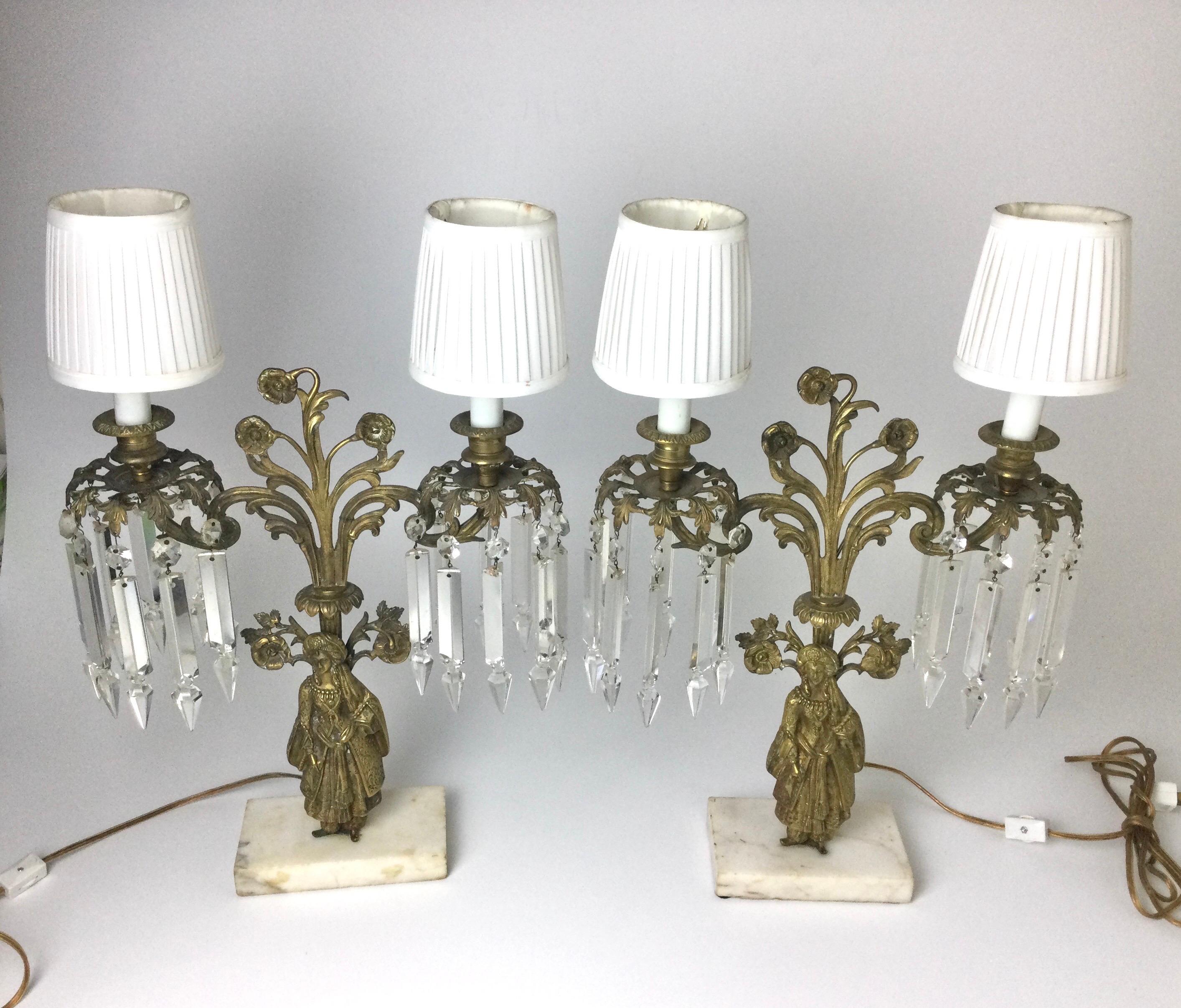 Nice old pair of candelabra that have been electrified. In good working order. Some small chipping to the prisms and 2 have been replaced. Come with the shades. Note minor staining to shades. Measures: 20
