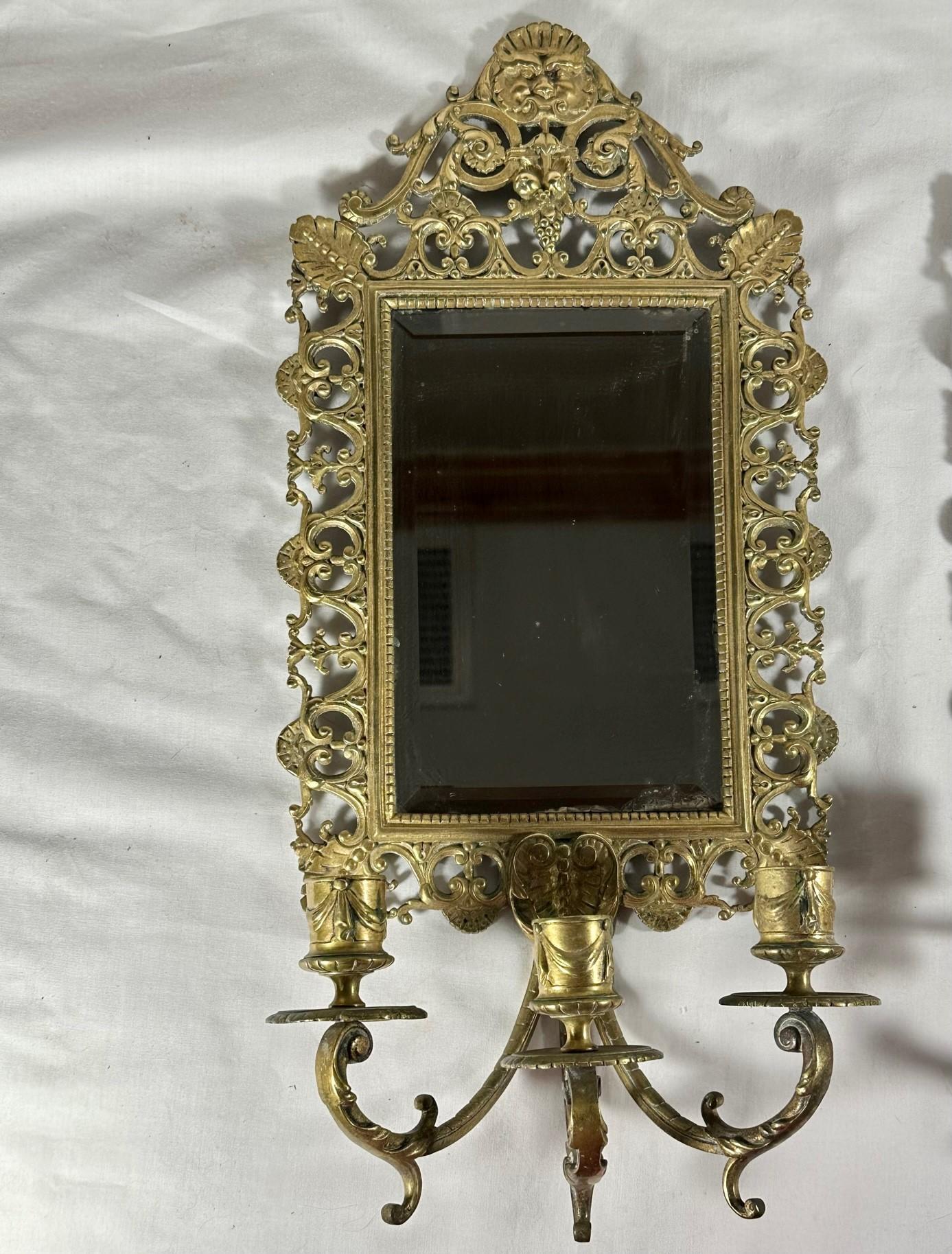 Pair Brass Mirrored Three Arm Candle Victorian Wall Sconces.

This pair of circa 1880s sconces reflect the importance of and pride in craftsmanship of the Victorian era exemplified by the execution of crisp and clear casting in solid brass. The