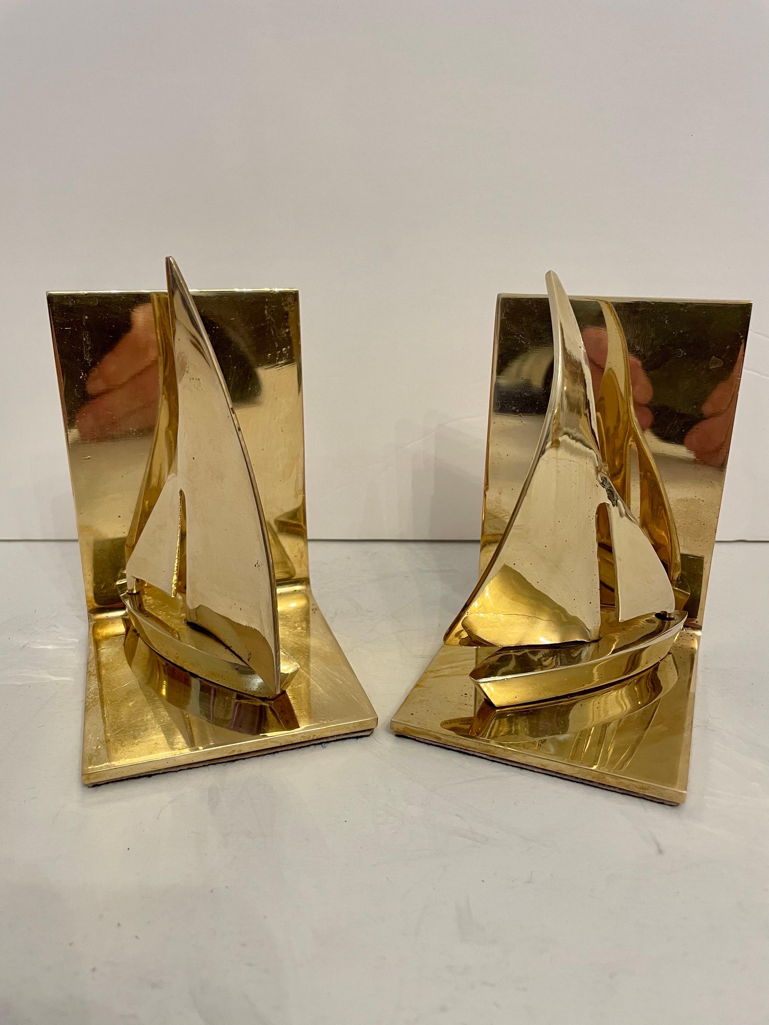 Brass Sailboat bookends. Nice detail in casting, heavy weight with substantial feel. Holds a shelves worth of books. Good condition, some slight patina. Thin pad on bottom to protect surfaces. Any dark or light spots are reflection only. Great for