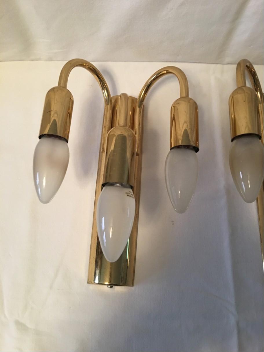 A lovely pair of three armed brass wall lamps in the Sputnik style from the 1960s. Each fixture requires three European E14 candelabra bulbs, each bulb up to 40 watts. In good working condition. Equipped with original 20th century European wiring.