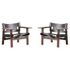 Un par de sillas «The Spanish Chair» de Børge Mogensen, de cuero negro y nogal aceitado