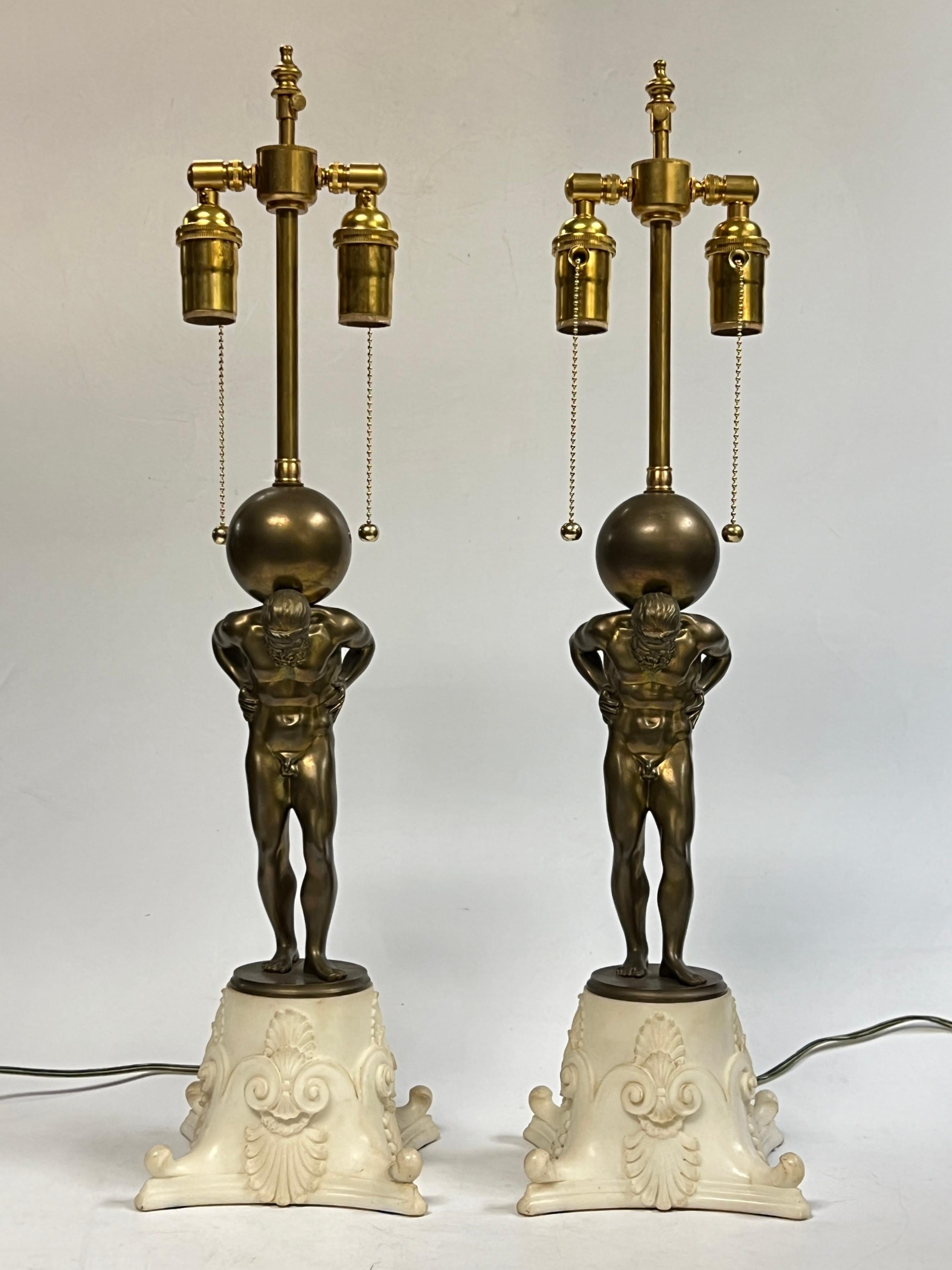 Coppia di figure in bronzo e marmo bianco del dio greco, Atlante, di E. F. A. Caldwell, con basi in marmo bianco finemente intagliate.
