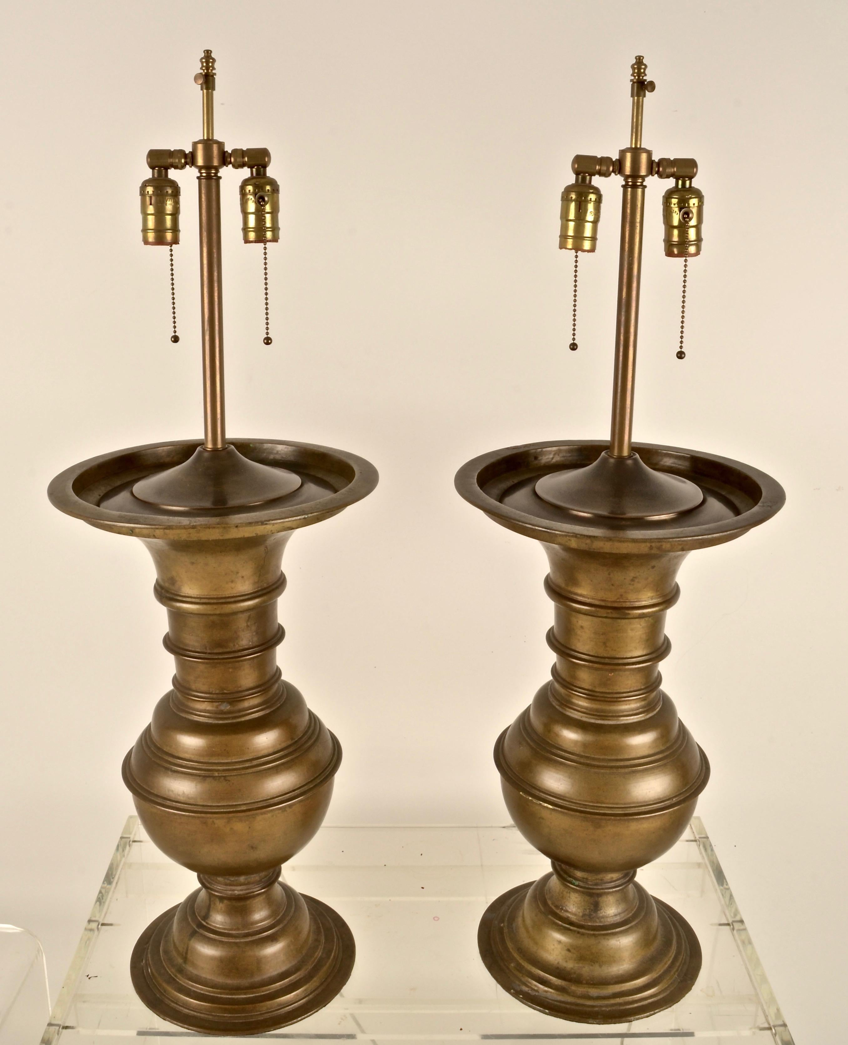 These lamps are heavy and substantial.The cast bronze has a lovely antiques patina showing natural oxidation. Quality lamp conversion features two bulbs on each lamp and adjustable shade rod. String shades in very good condition included. Lamps