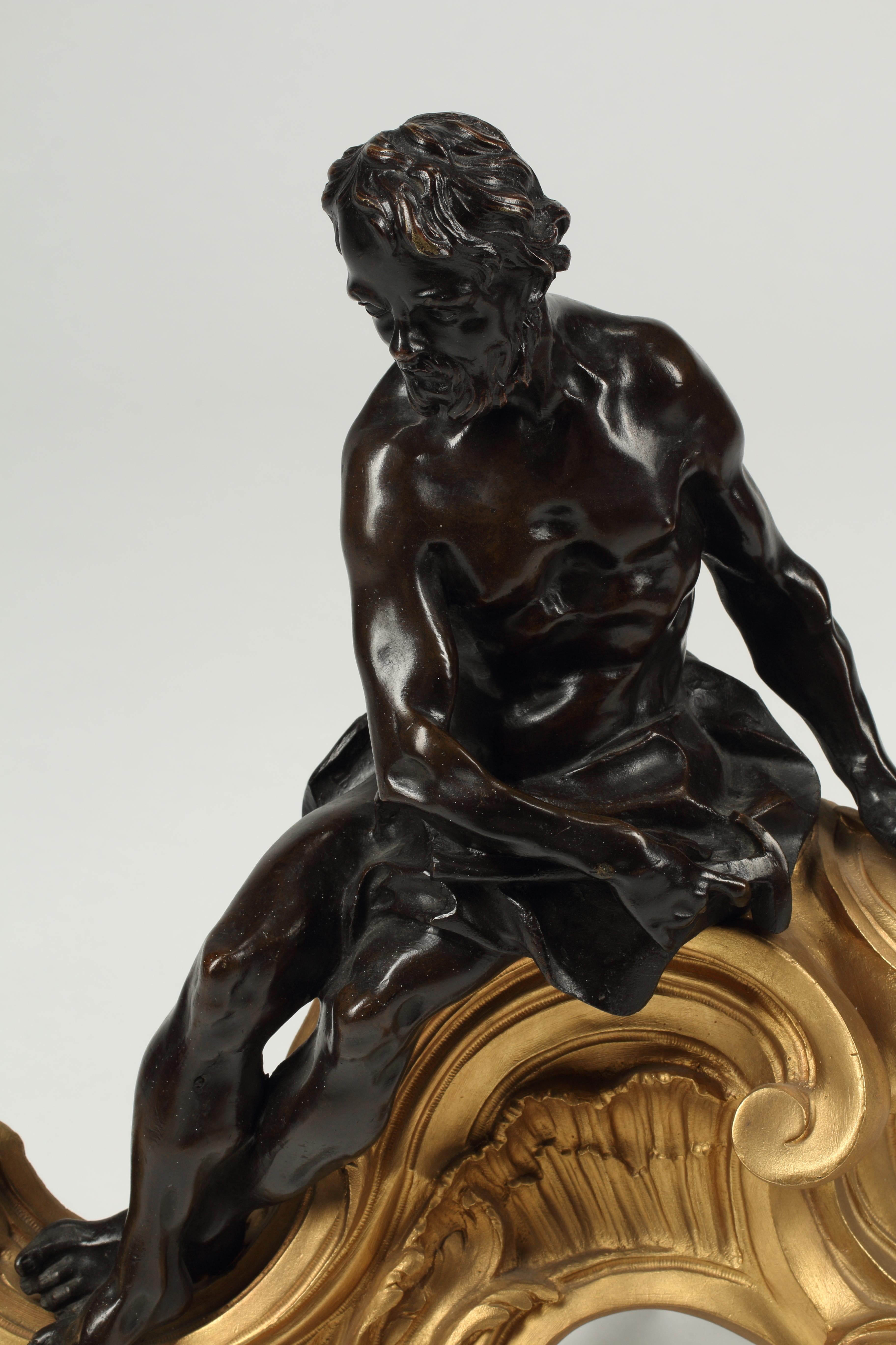 Paire de chenets en bronze patiné et doré de style Louis XV, opposés au XIXe siècle.
Une figure masculine et une figure féminine patinées en position allongée, surmontées de belles volutes en bronze doré. 