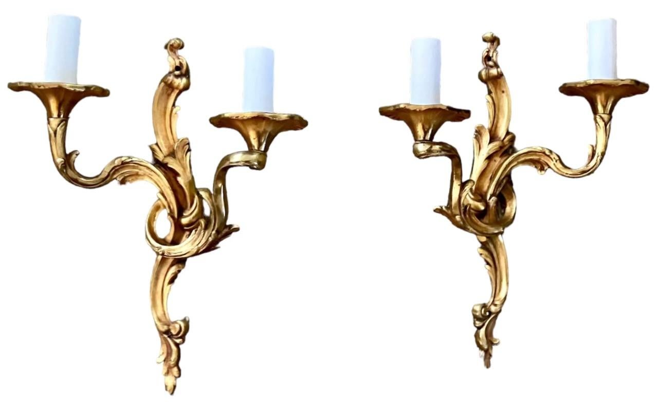Coppia di appliques in bronzo in stile Luigi XV.  Coppia di applique d'epoca a due bracci in stile Luigi XV appena elettrificate.  Italia, circa 1920. 

Dimensioni: 12