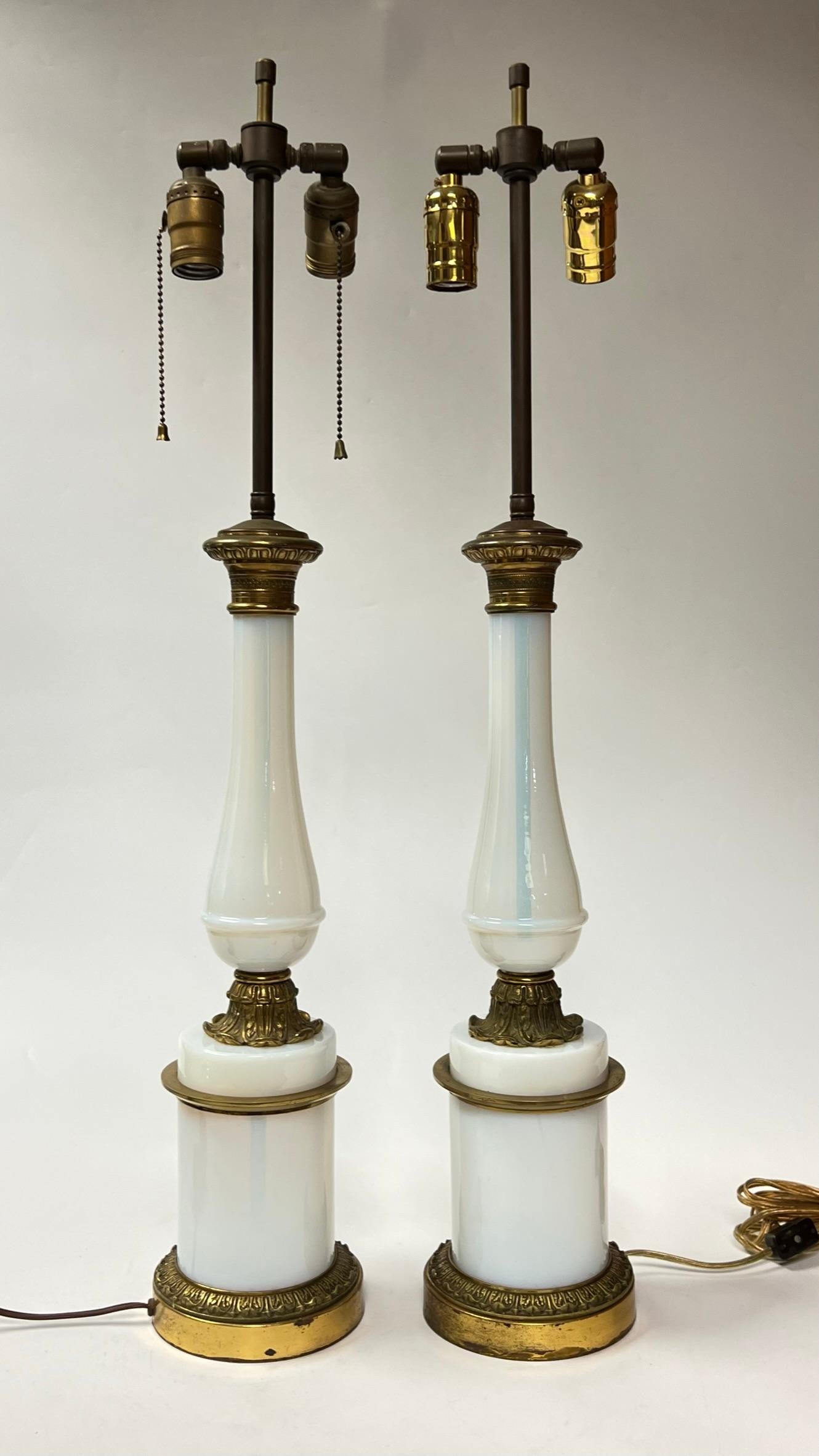 Pair of antique lamps in the neoclassical style with gilt brass and bronze mounts and standards crafted from blown opaline glass.  