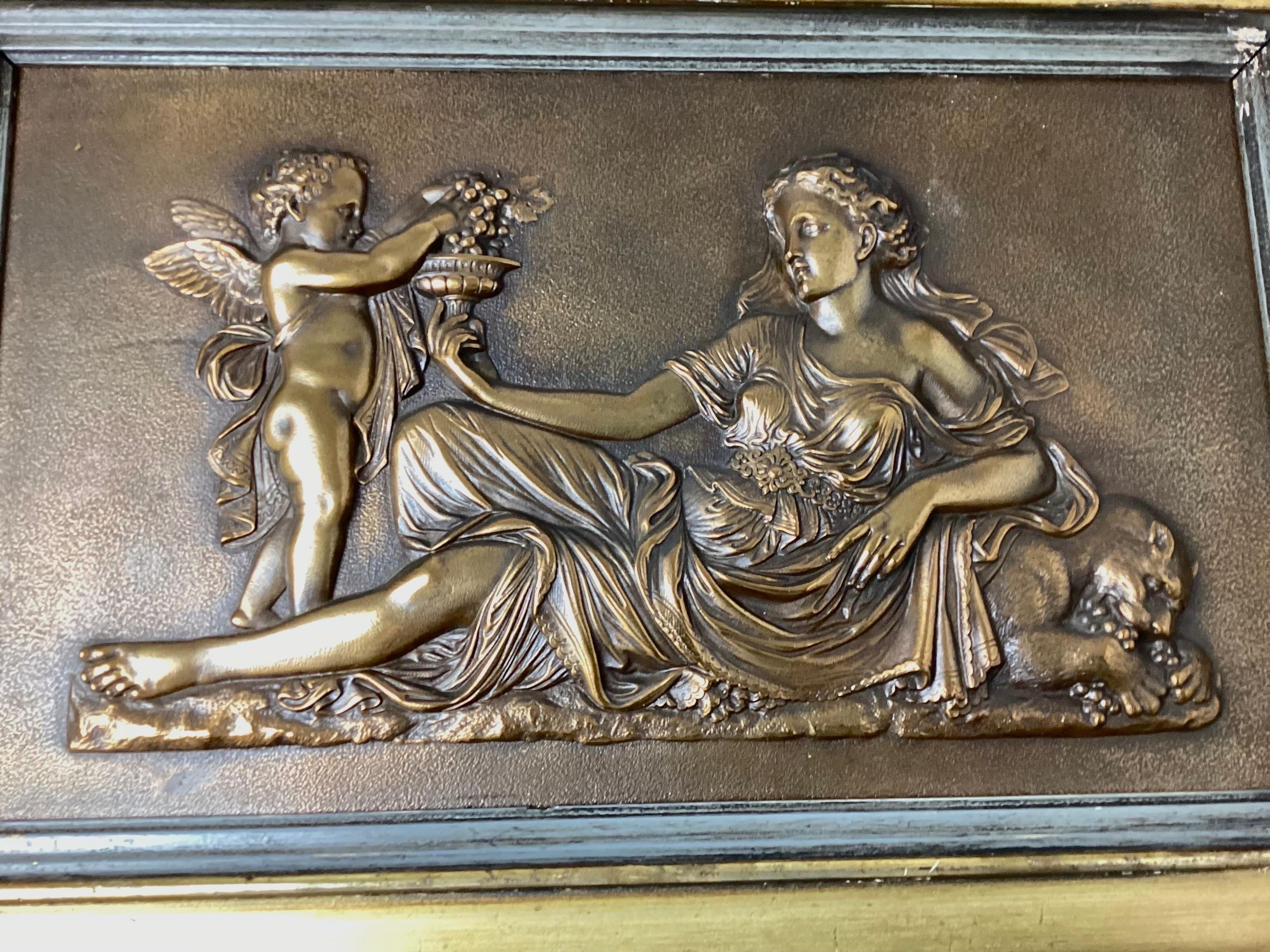 Pair bronze relief wall plaques framed woman with cherub. By Boston Metallic Compression Casting Co. Who ever re-framed in the 1994 included a rubbing of the mark of the back. Each frame measures 18 1/2 by 12 1/4. Each have subtle differences. Old